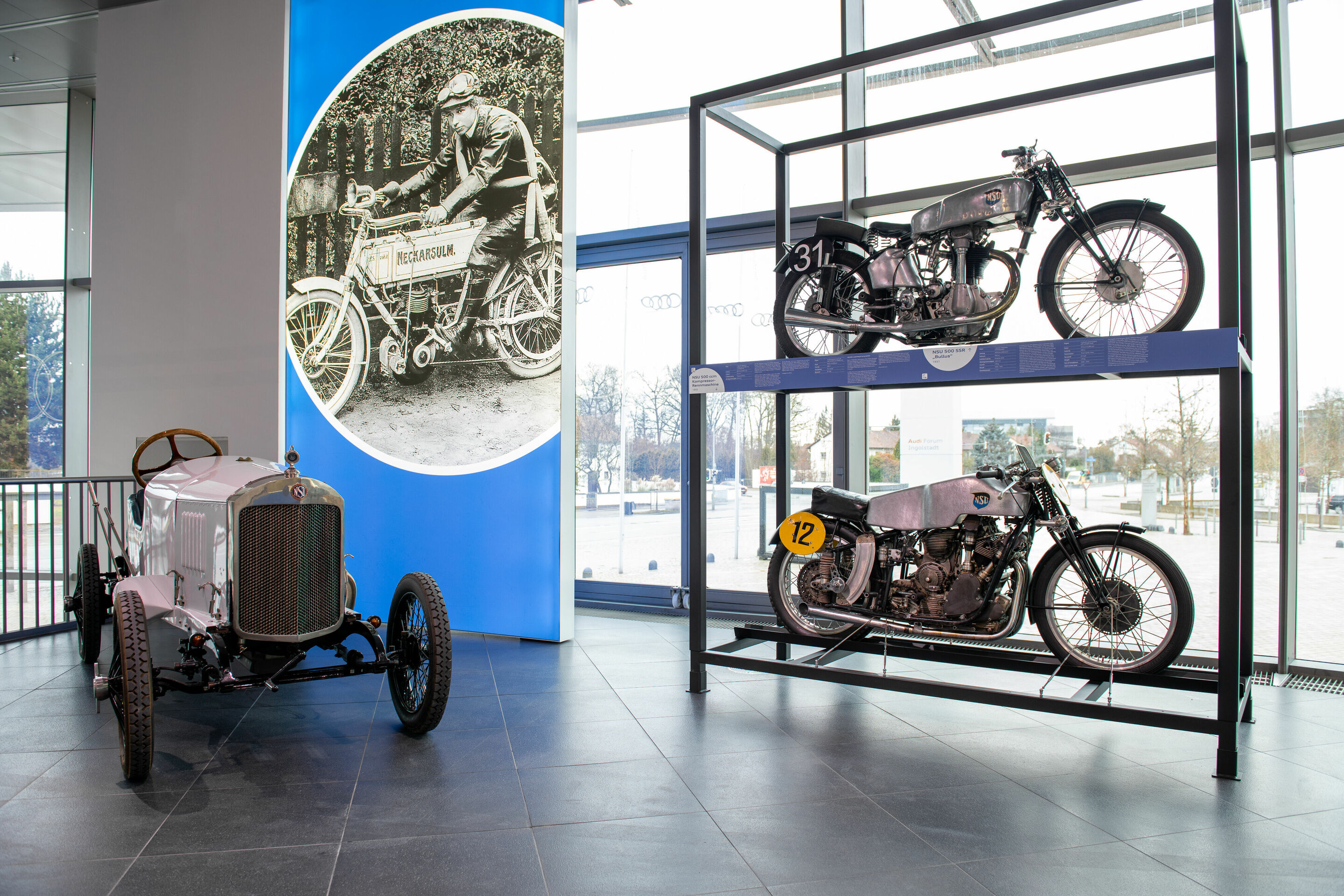 Off to the museum via app: Audi Tradition goes digital with its new special exhibition “Der fünfte Ring“ - Exhibits in the new special exhibition “Der fünfte Ring”: The photo in the background shows Gertrude Eisemann – the “master of the motorcycle” –...