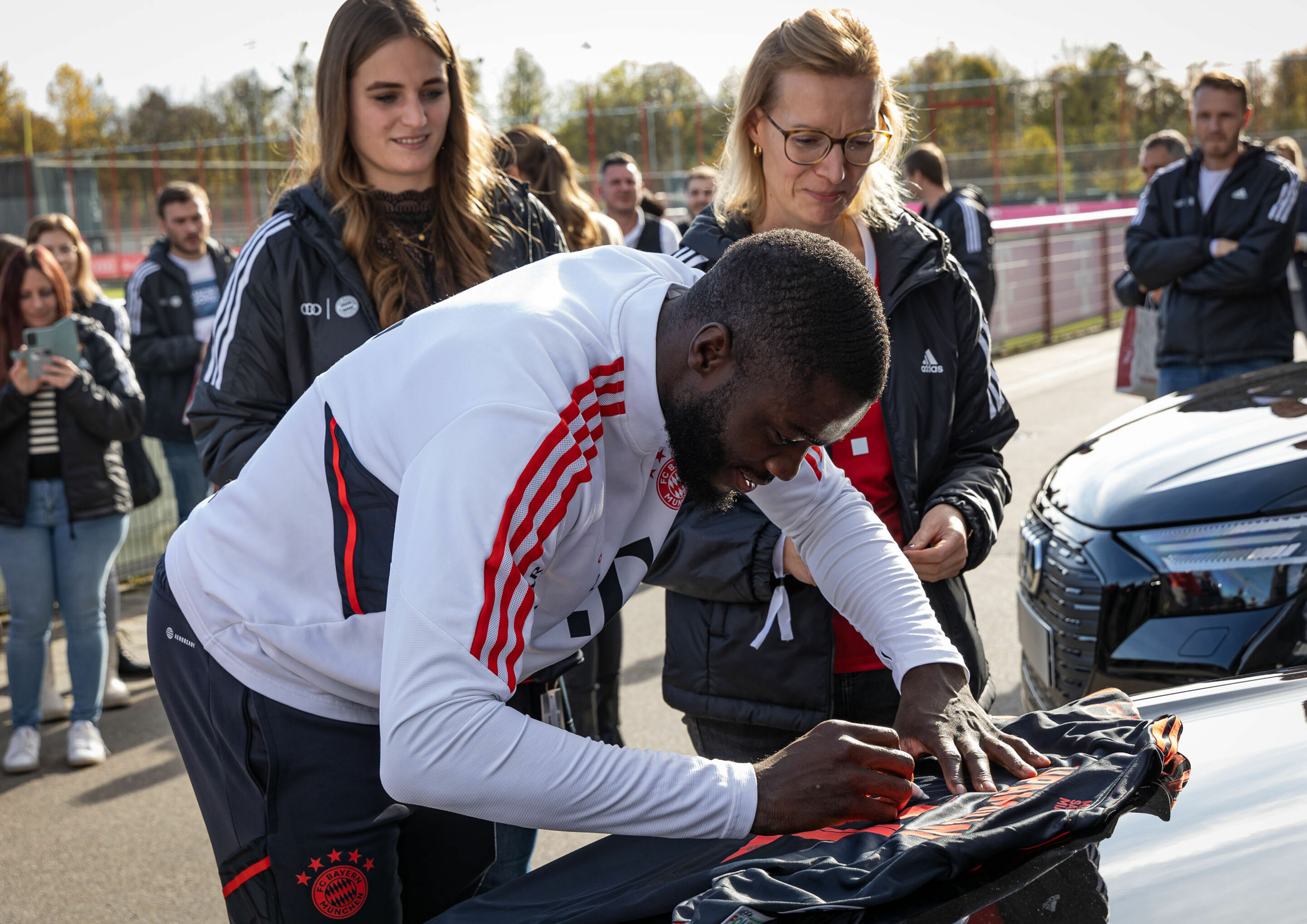 Audi vehicle handover - FC Bayern’s Dayot Upamecano signs autographs during the vehicle handover at Säbener Straße.
