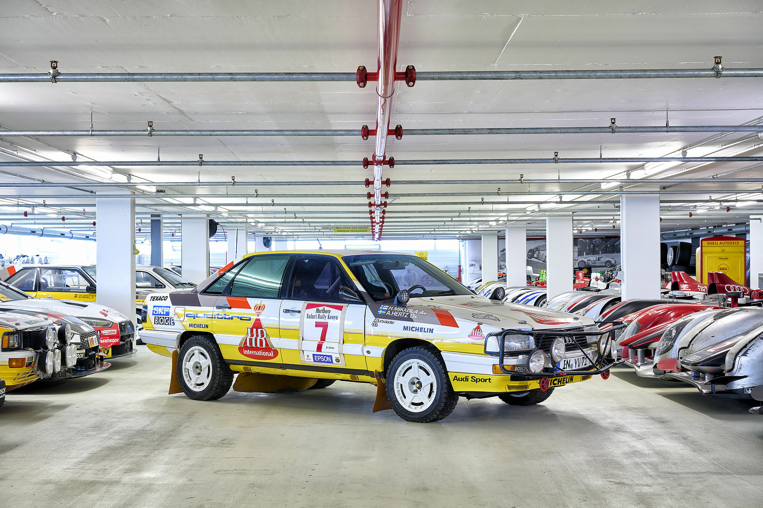 Audi Tradition Buch „Einblicke“ - Der Audi 200 quattro Safari in der historischen Fahrzeugsammlung der AUDI AG – umrahmt von weiteren Rallye-Ikonen und Le-Mans-Boliden.