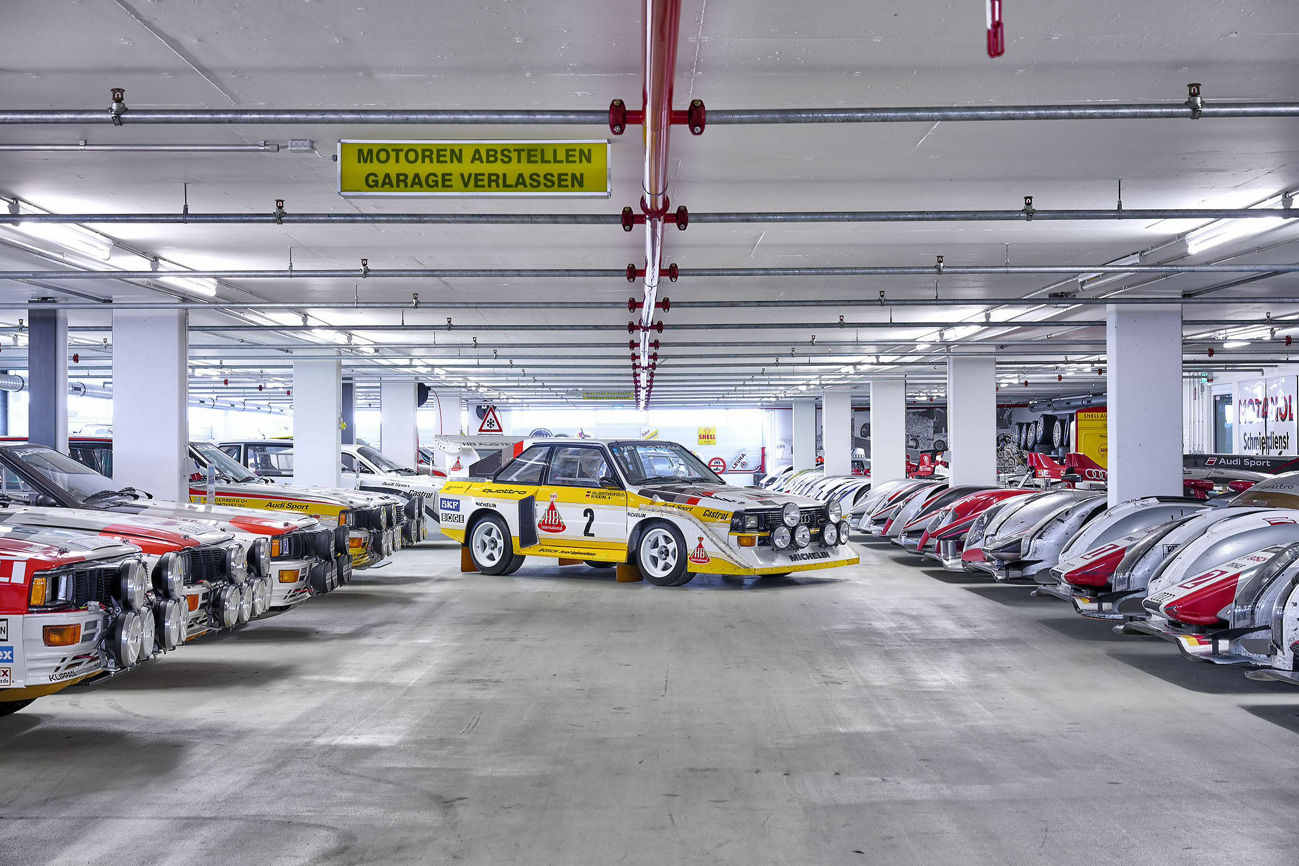 Audi Tradition Buch „Einblicke“ - Der Audi Sport quattro S1 E2 in der historischen Fahrzeugsammlung der AUDI AG – umrahmt von weiteren Rallye-Ikonen und Le-Mans-Boliden.
