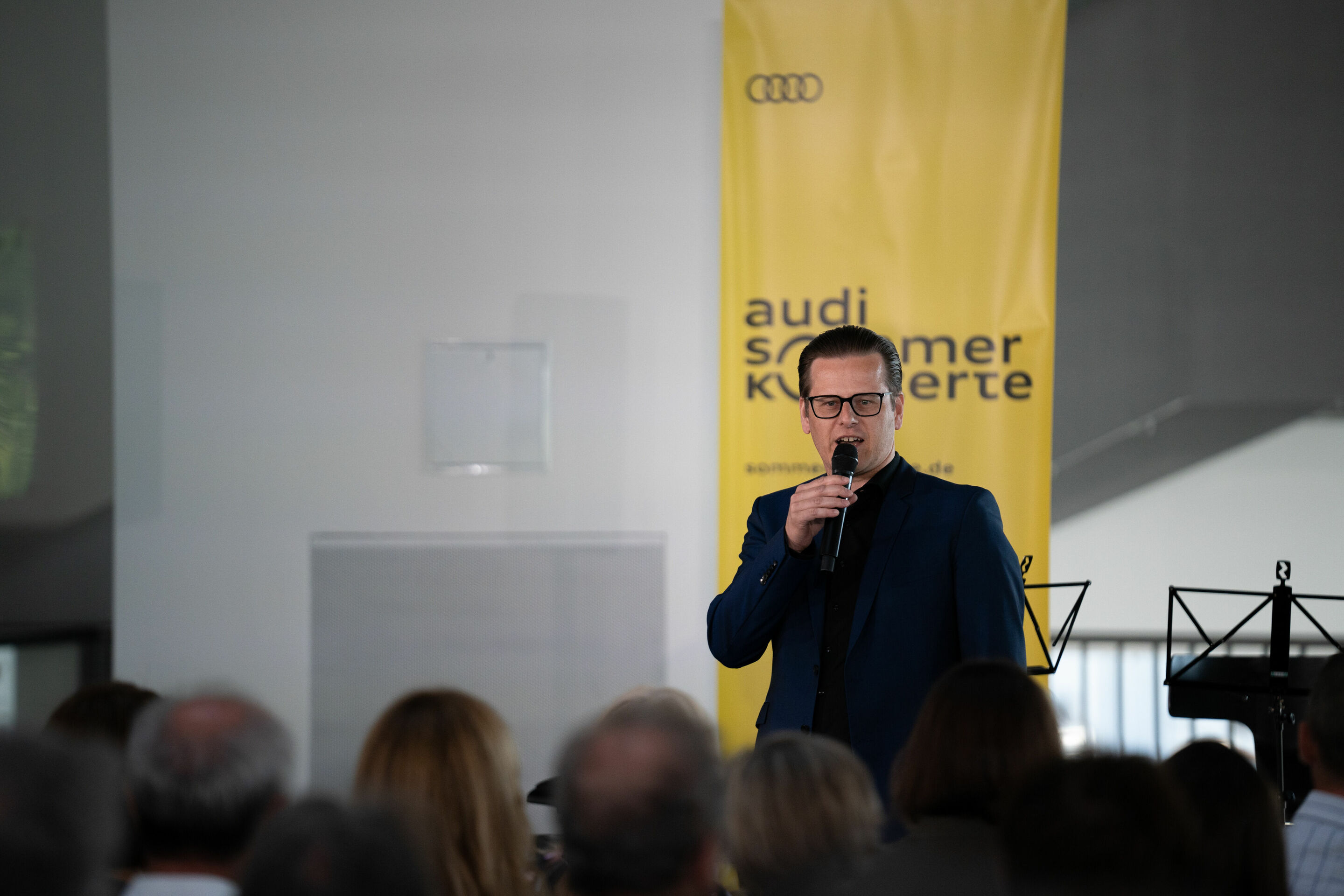 Audi Sommerkonzerte 2023 - Sebastian Wieser, künstlerischer Leiter der Audi Sommerkonzerte, begrüßt das Publikum im Audi museum mobile.
