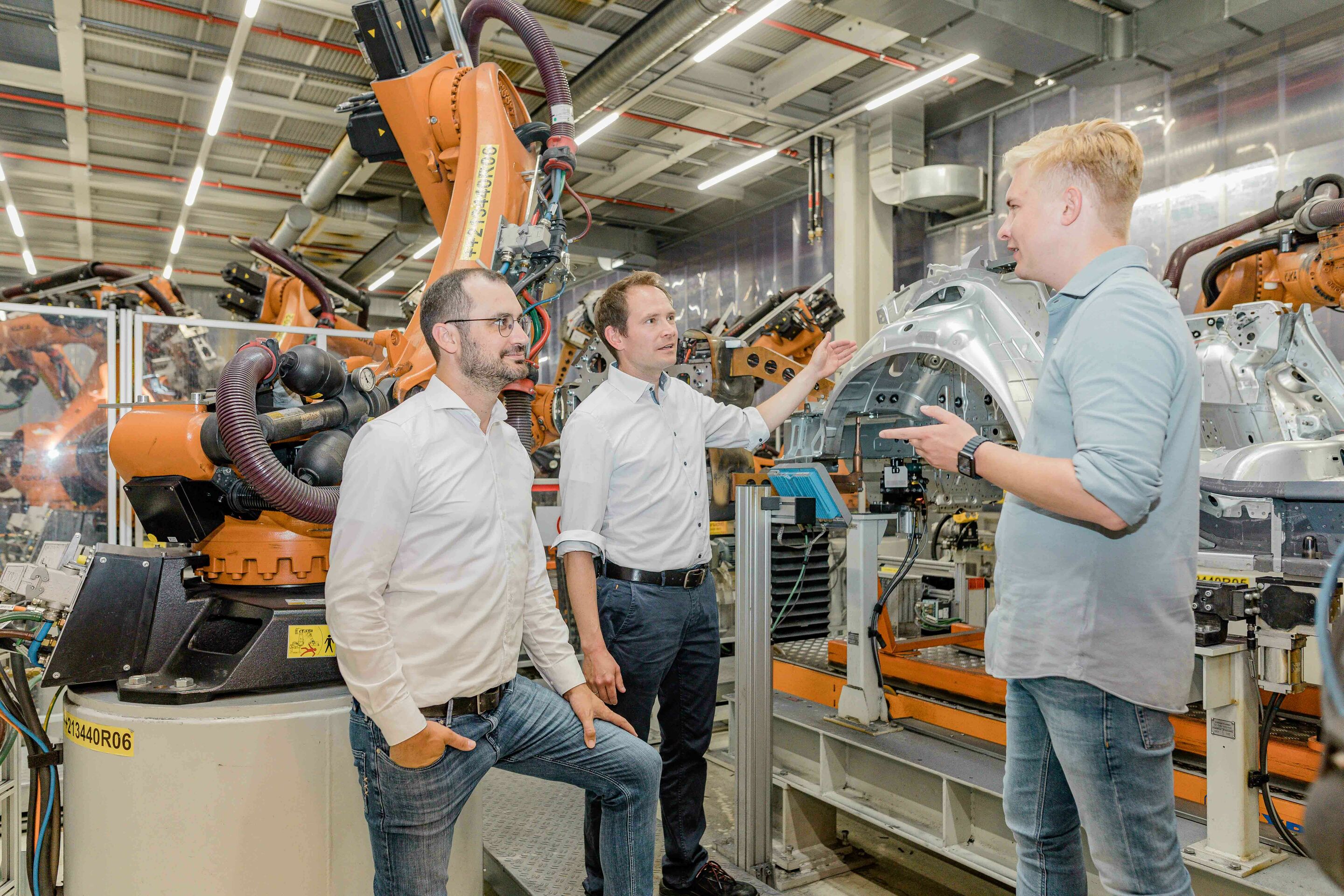 Audi begins roll-out of artificial intelligence for quality control of spot welds - A team led by project managers Mathias Mayer (left) and Andreas Rieker (center), seen here exchanging ideas with Data Analyst Nick Hauck, developed an AI for quality control...
