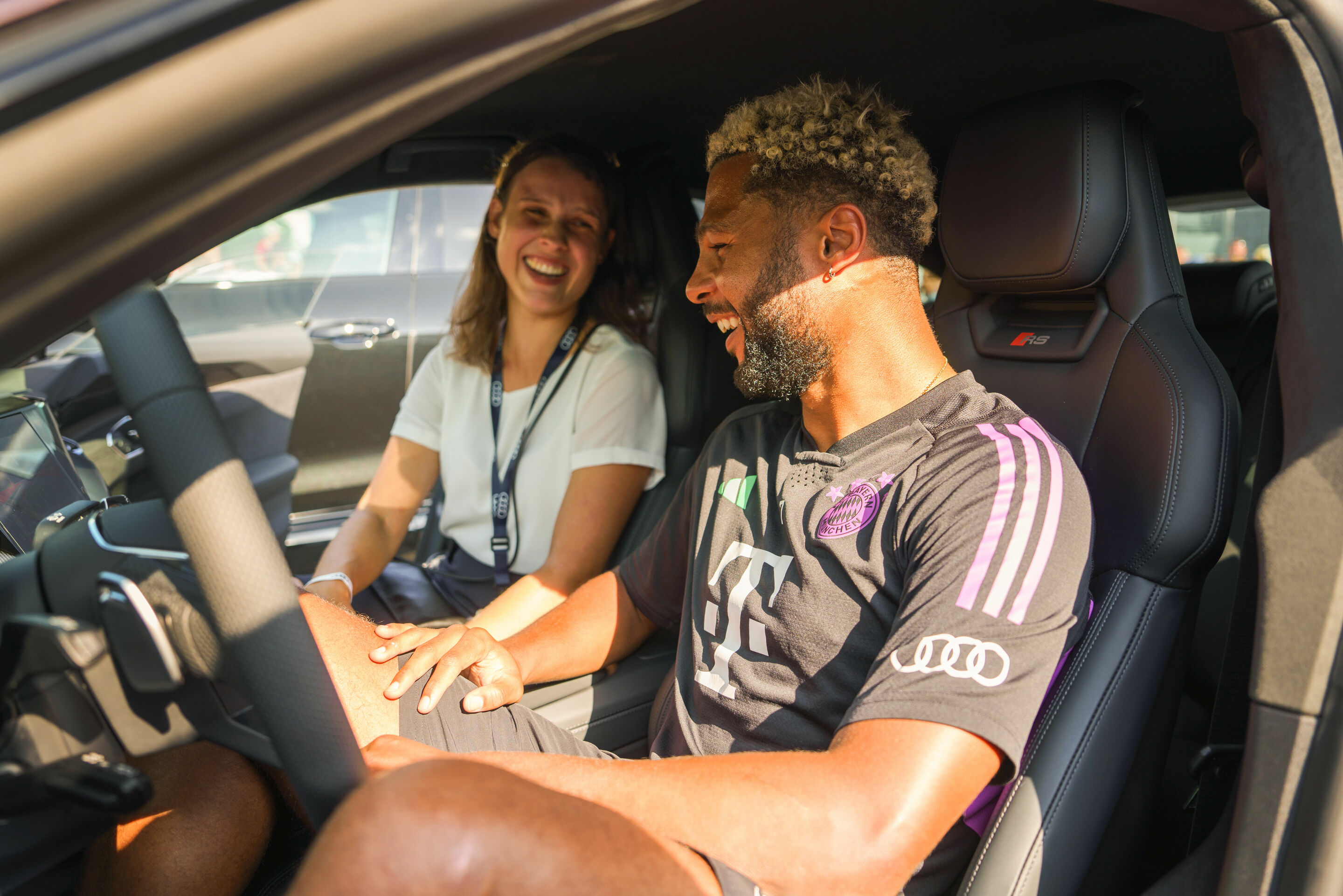 FC Bayern erhält neue Dienstwagen – Audi veräußert Spielerautos - Fahrzeugübergabe auf der Audi Piazza in Ingolstadt: Serge Gnabry vom FC Bayern München fährt in der Saison 2023/24 einen Audi RS e-tron GT in der Farbe Kirschschwarz Perleffekt.