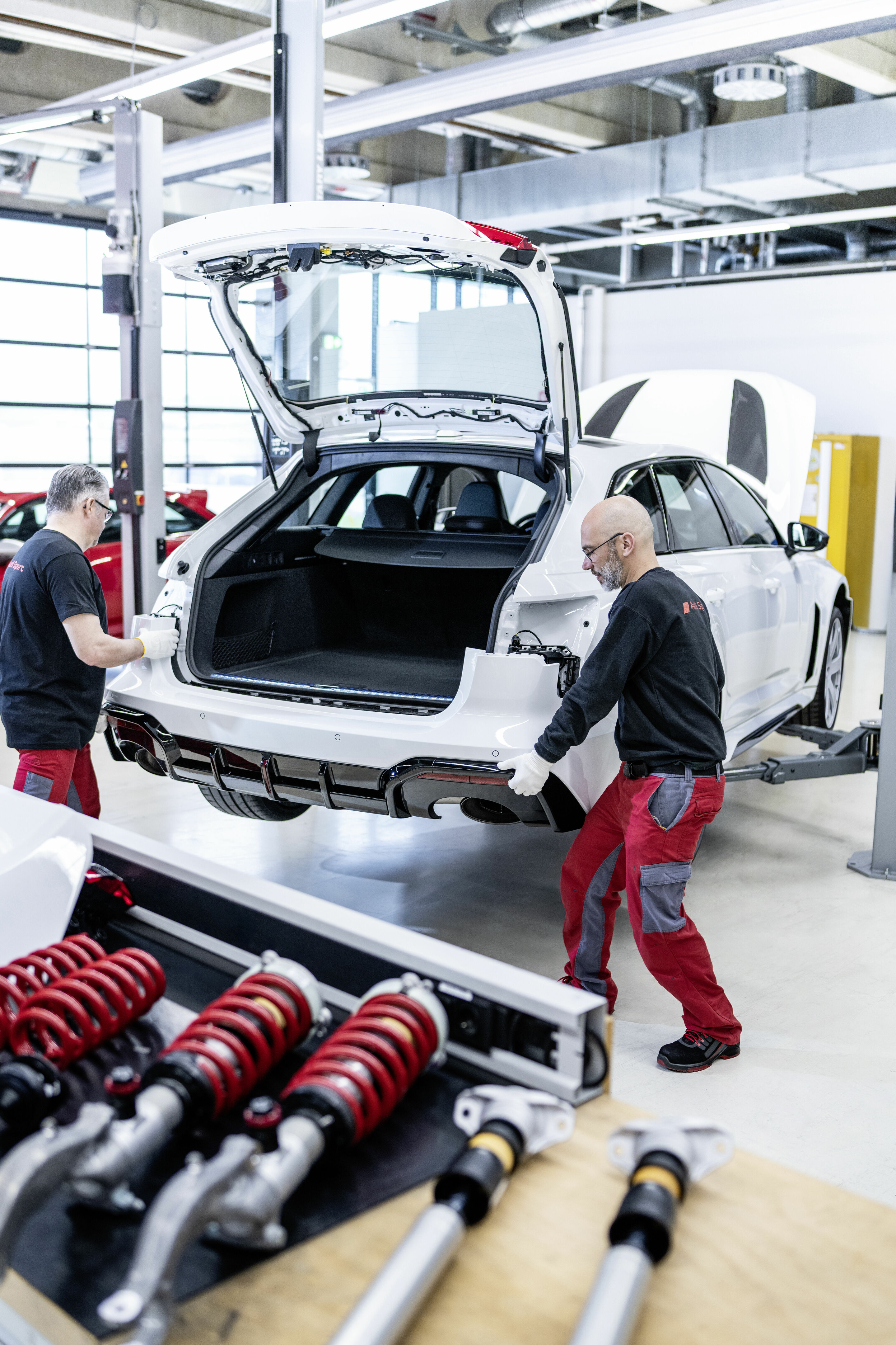Audi RS 6 Avant GT - Zwei der insgesamt fünf Mitarbeiter_innen der Böllinger Höfe vervollständigen die Montage des neuen Audi RS 6 Avant GT von Hand. Zahlreiche Anbauteile, darunter auch die neu gestaltete Heckschürze, bestehen aus Carbon.