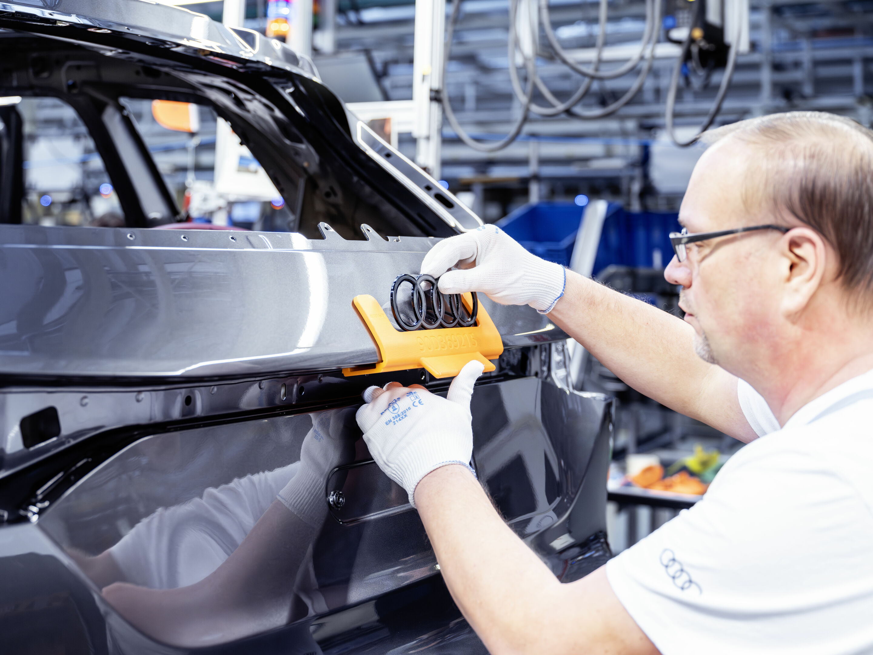 Production Audi Q6 e-tron at the Ingolstadt site - The Audi rings are being attached.
