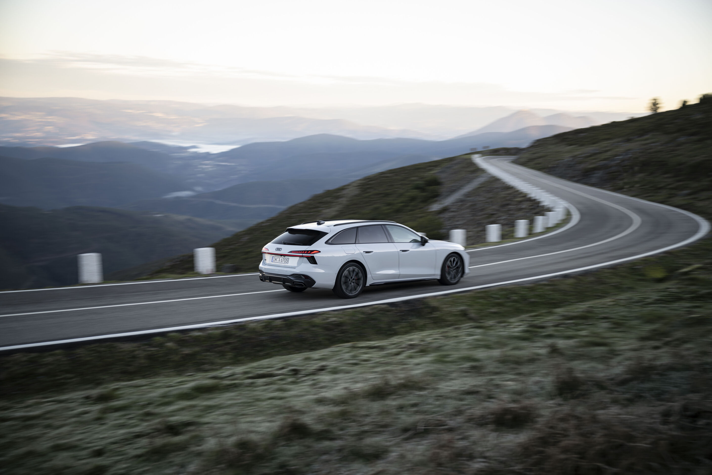 Vernetzte Entwicklung: So wird der Audi A6 Avant zum erstklassigen Reisebegleiter - Ein Audi A6 Avant in Gletscherweiß Metallic fährt eine kurvenreiche Passstraße entlang. Im Hintergrund liegt der Horizont.