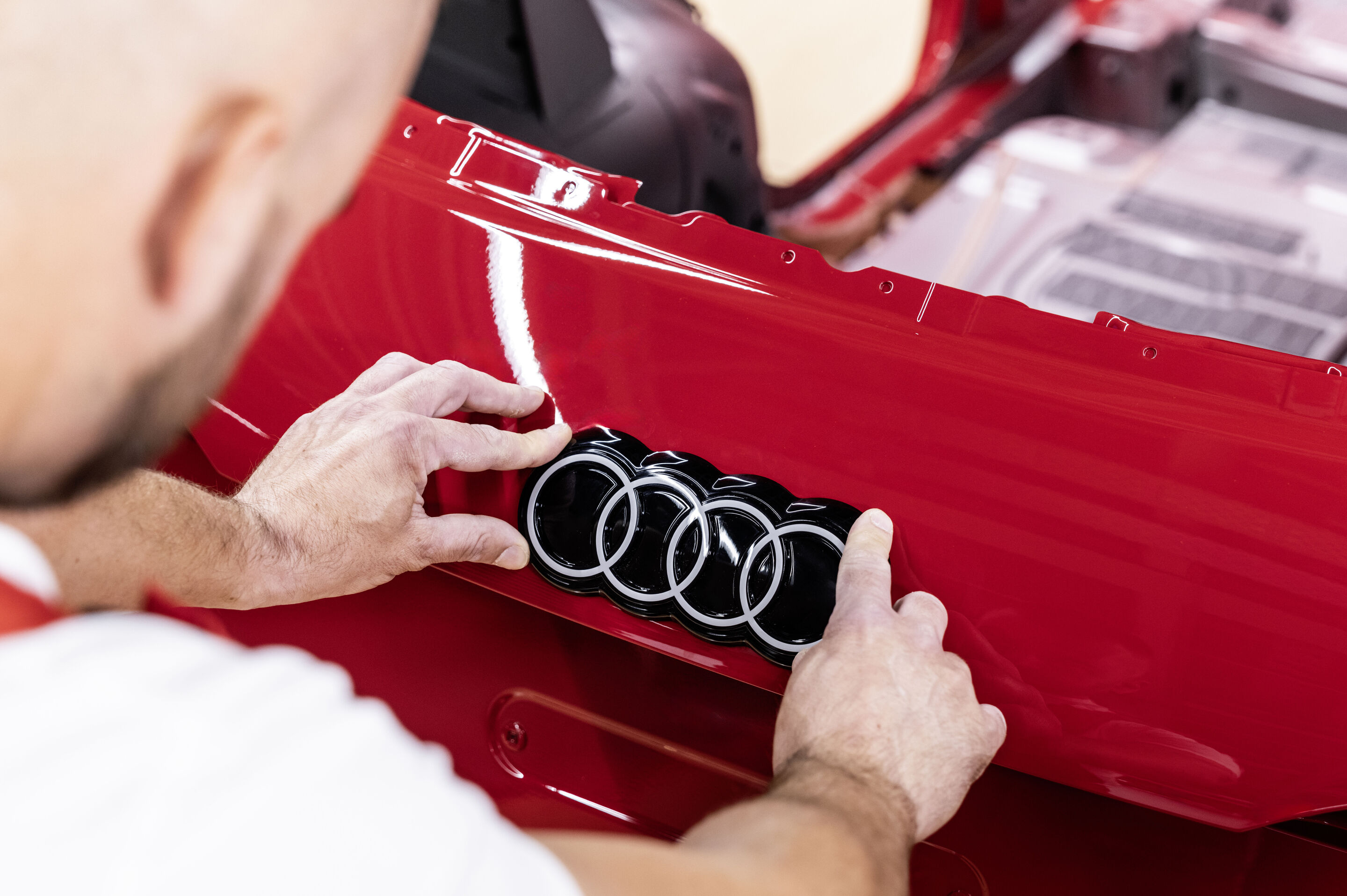 Audi Q3 SUV - The Audi Q3 is manufactured at Audi Hungaria in Győr. Pictured: Assembly of the Audi rings, Colour: Progressive red metallic