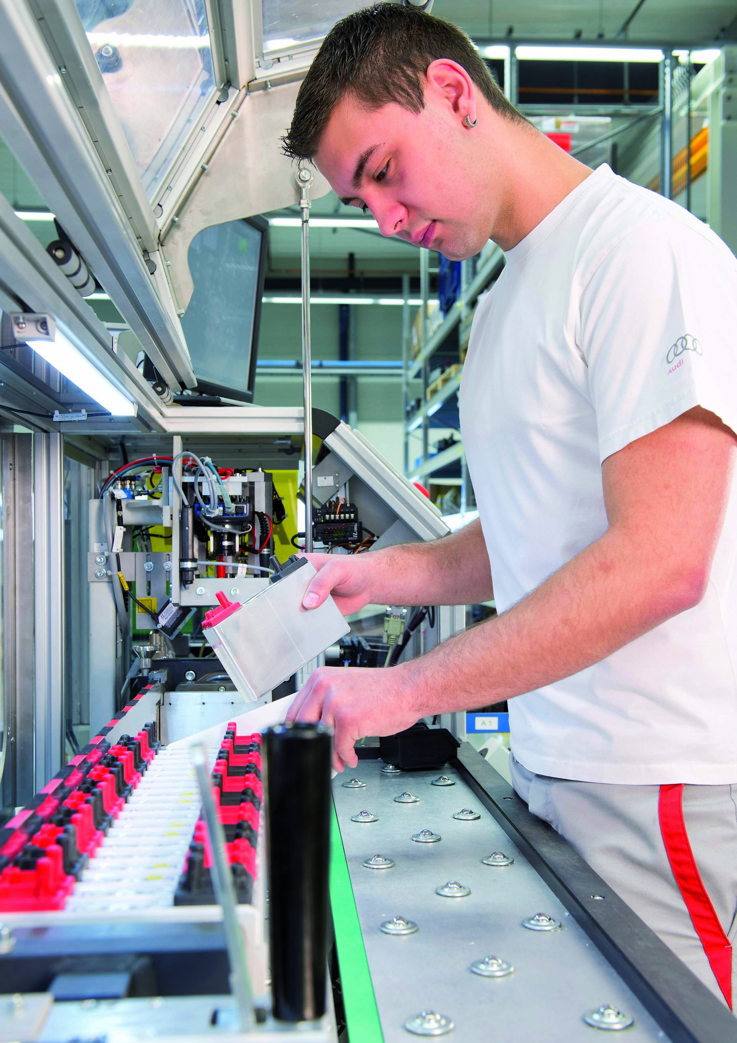 High-Voltage Battery Project House - An employee inserts parts for a battery cell module.
