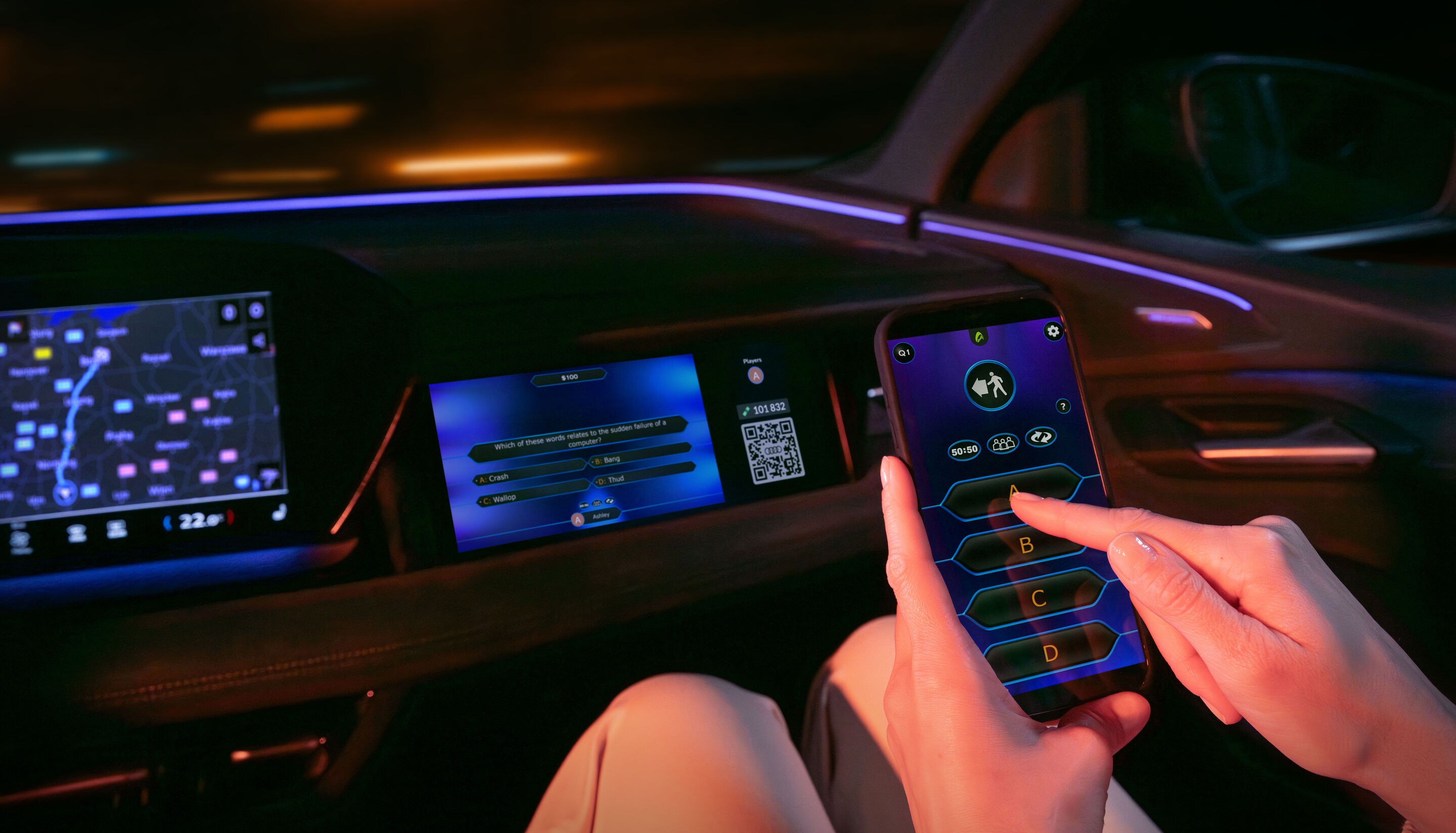 Gaming fun on the go: Audi integrates AirConsole - The AirConsole gaming platform app and the game Who Wants to Be a Millionaire? run on the front passenger display in an Audi. A person is holding a smartphone in front of the display. They use the smartphone...