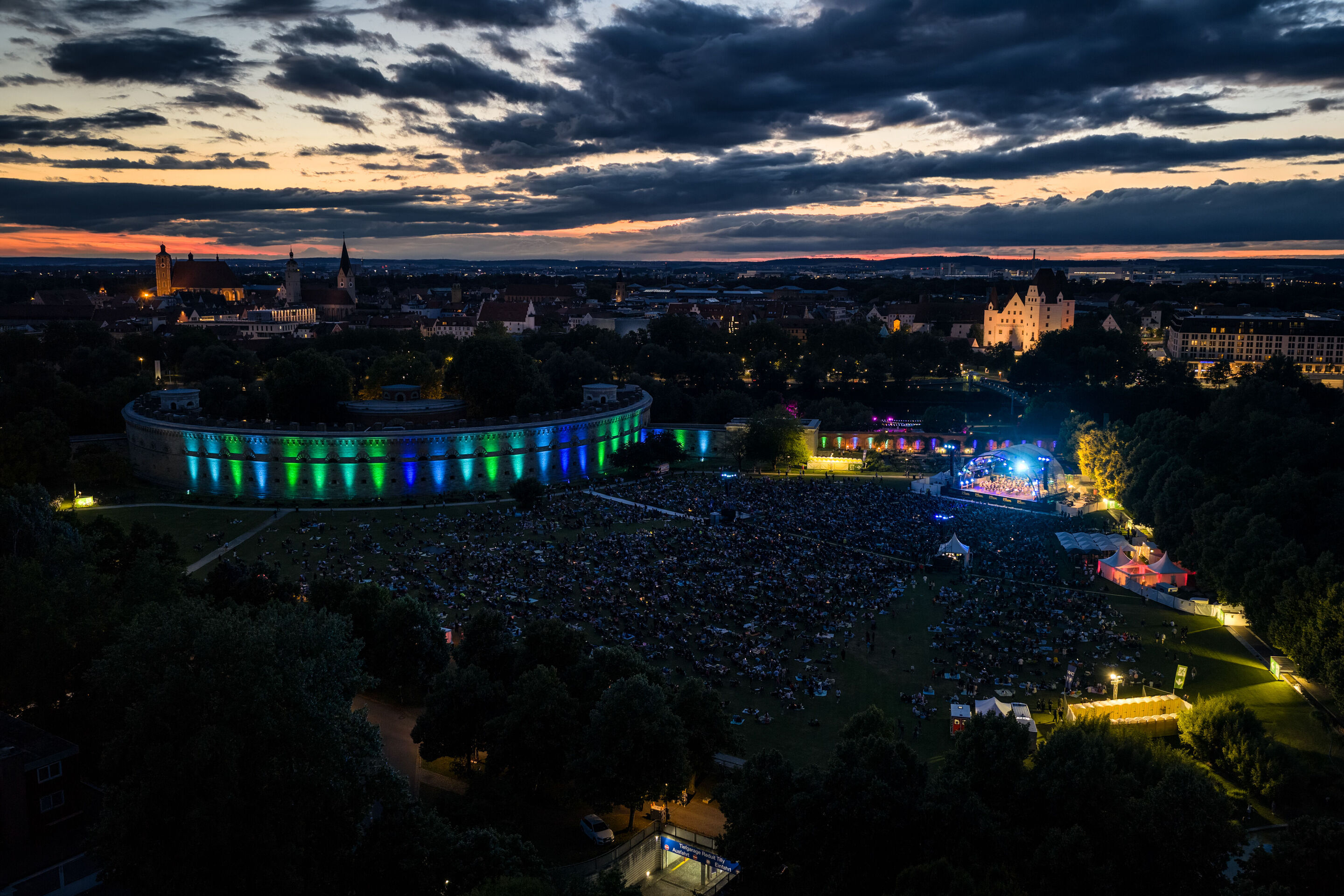 Classic Open Air – musical highlights with the Audi Philharmonic Wind Orchestra - Bird’s-eye view at dusk of the Classic Open Air event featuring the Audi Philharmonic Wind Orchestra as part of the Audi Summer Concerts in Klenzepark in Ingolstadt. On...