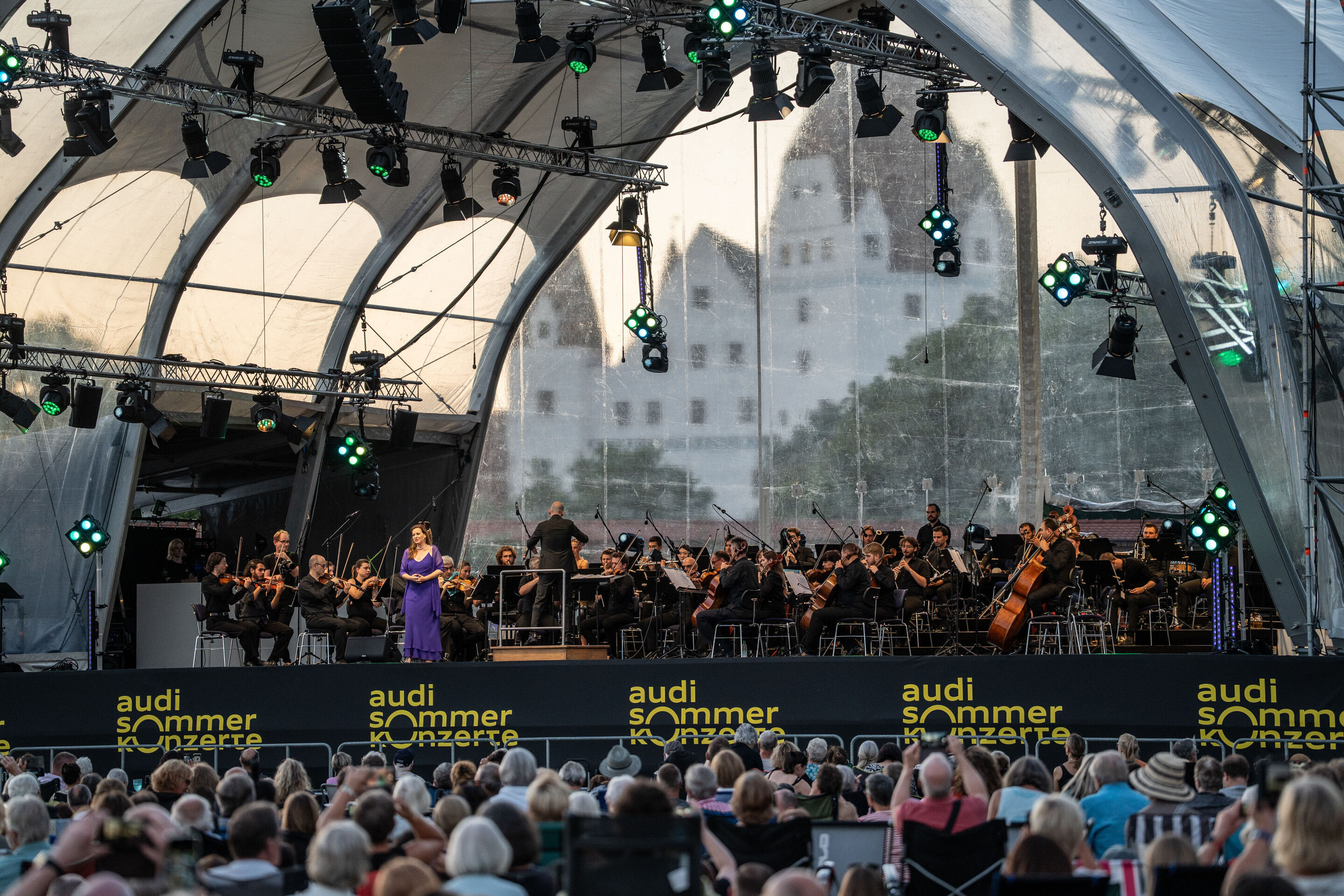 Klassik Open Air – Deutsch-italienische Opernnacht mit dem Georgischen Kammerorchester Ingolstadt - Beim Klassik Open Air im Klenzepark im Rahmen der Audi Sommerkonzerte steht Sopranistin Hila Baggio auf der Bühne, im Hintergrund spielt das Georgische...