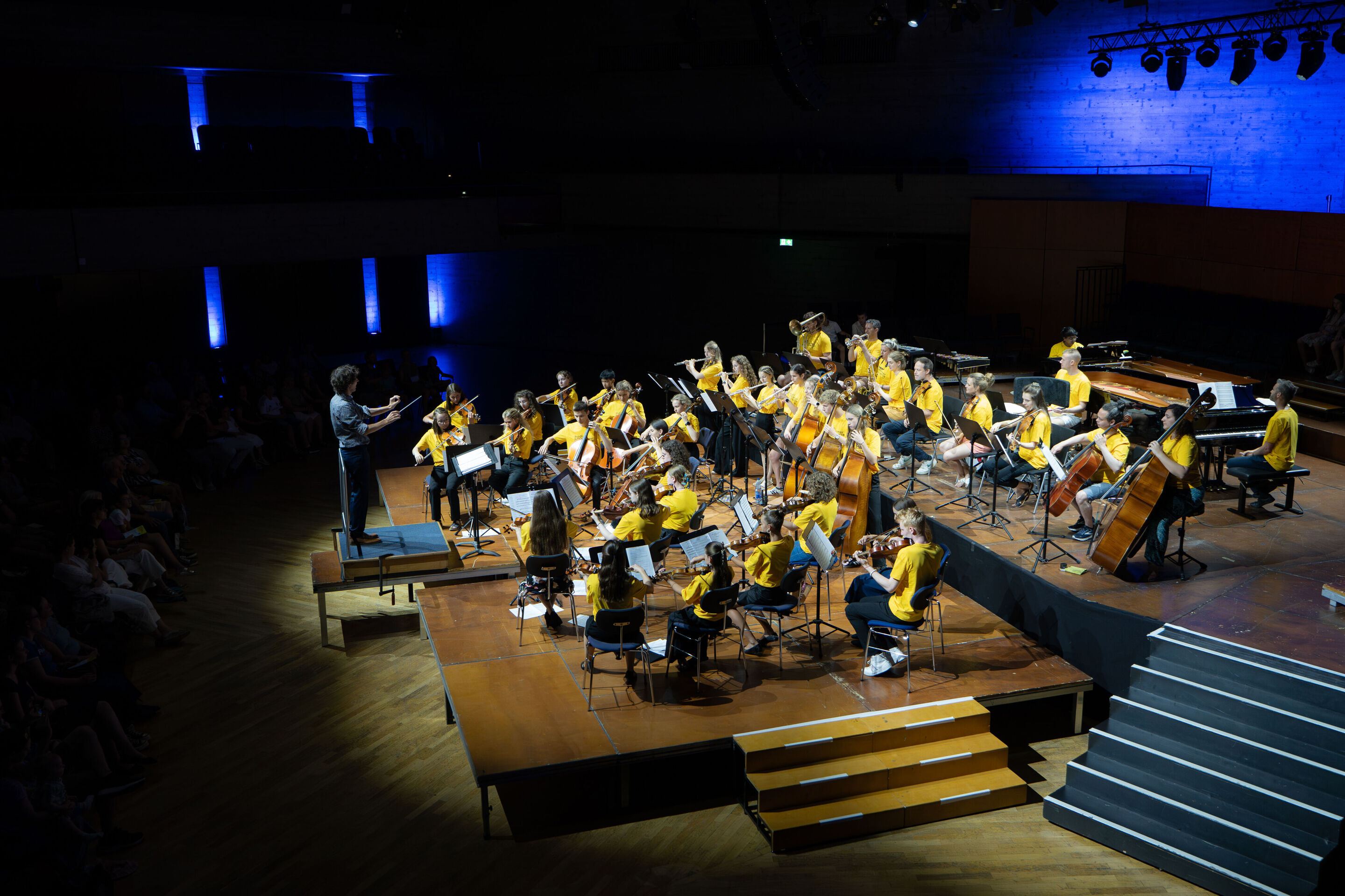 Public workshop with pupils from the region and the Aurora Orchestra - On the stage of the Ingolstadt festival hall, the musicians of the Aurora Orchestra can be seen in the background, while in front students are performing under the direction of Klaus...