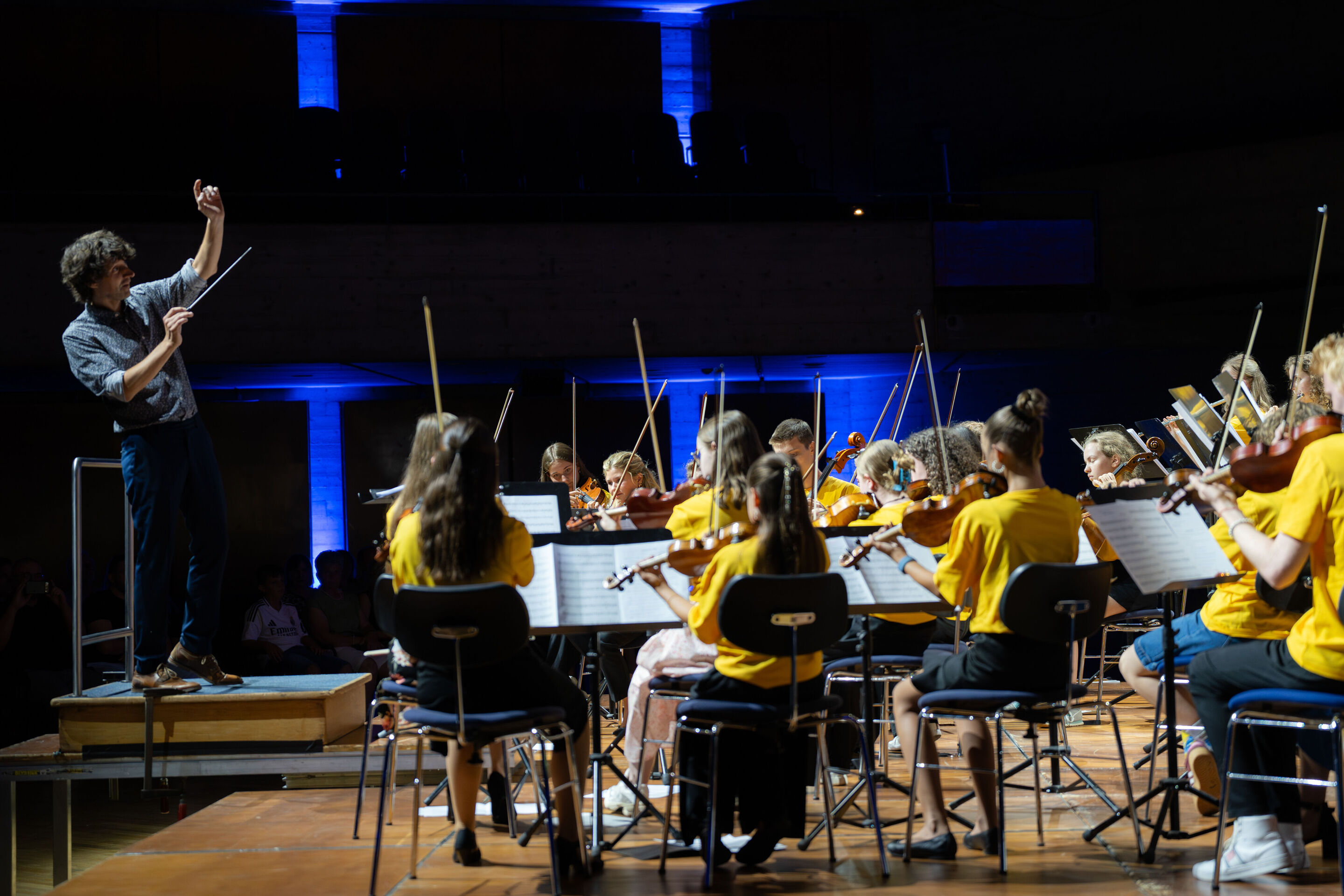Public workshop with pupils from the region and the Aurora Orchestra - Klaus Hoffmann is conducting the students performing on stage at the Ingolstadt festival hall.