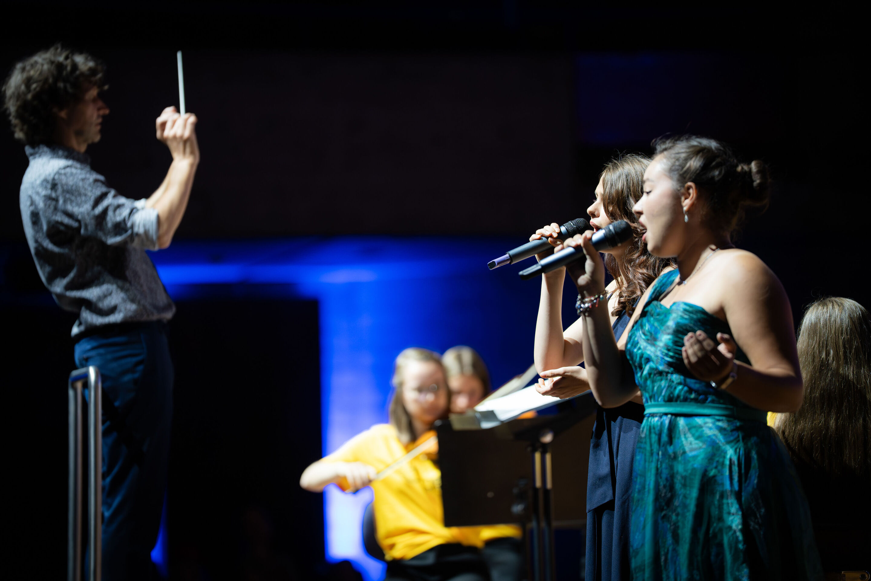 Public workshop with pupils from the region and the Aurora Orchestra - The soloists Sarah Seyfert and Miriam Werner (11th-grade students at Gnadenthal-Gymnasium) are singing on the stage of the Ingolstadt festival hall. On the left, conductor Klaus Hoffmann...