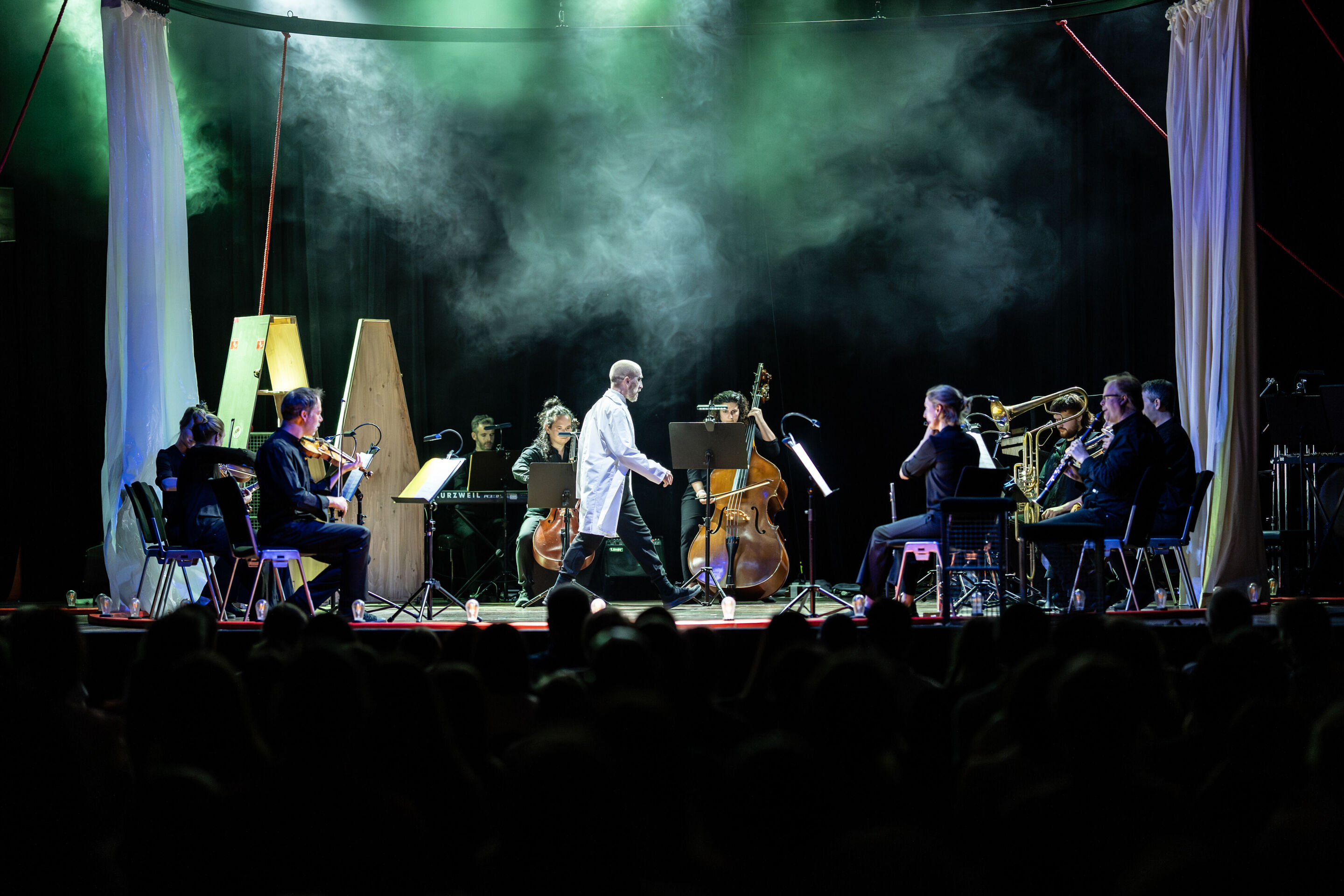 „Carnival“: Inszeniertes Familienkonzert rund um die fabelhafte Welt der Instrumente - Auf der Bühne im Festsaal Ingolstadt spielen Mitglieder des Aurora Orchestra kreisförmig angeordnet auf ihren Instrumenten. In der Mitte geht Tänzer Christopher Akrill...