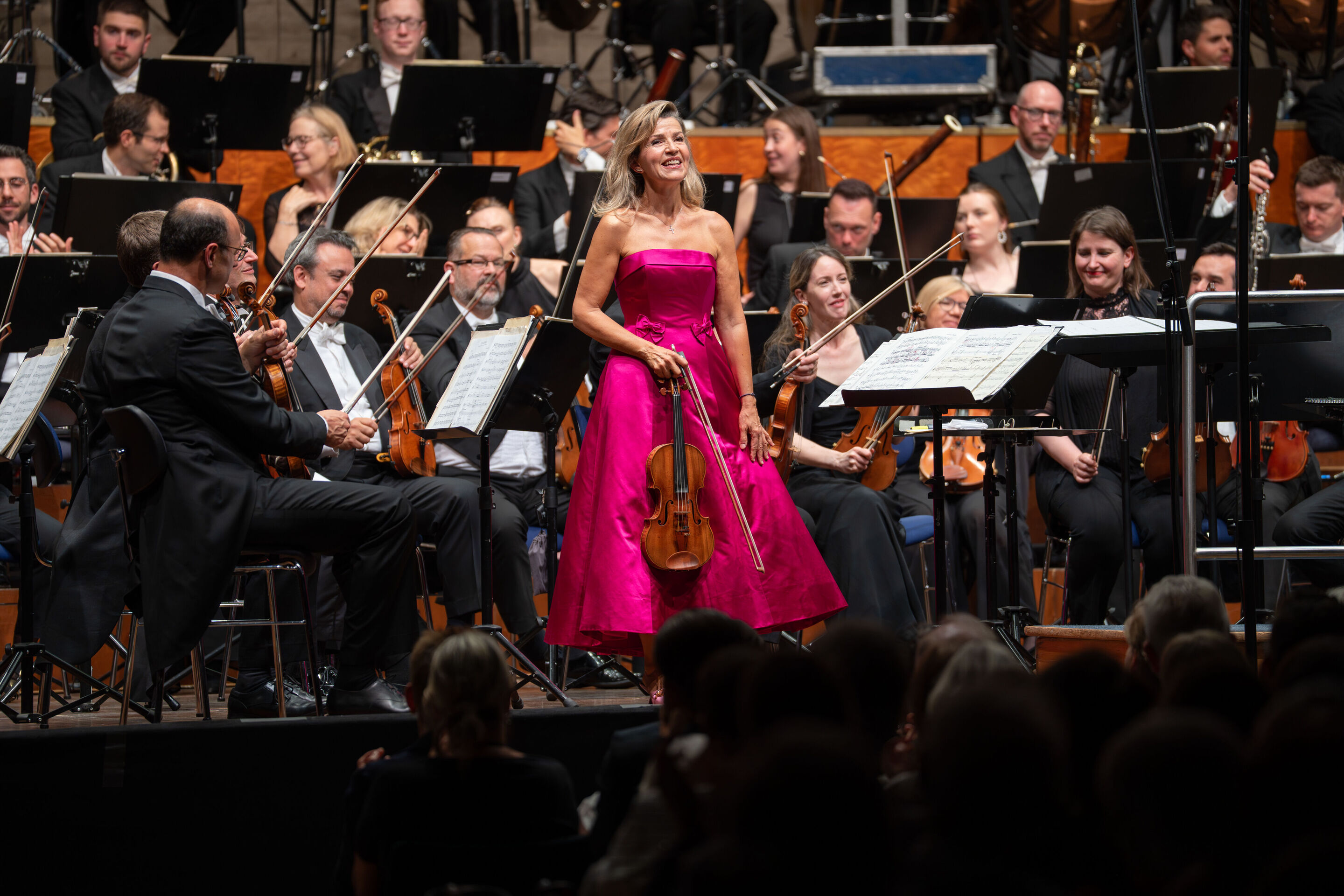 „Across the Stars“: Filmmusik mit Weltstar Anne-Sophie Mutter und dem Royal Philharmonic Orchestra - Auf der Bühne des Festsaals Ingolstadt steht in der Mitte Stargeigerin Anne-Sophie Mutter mit ihrer Violine, hinter ihr sind Musizierende des Royal Philharmonic...