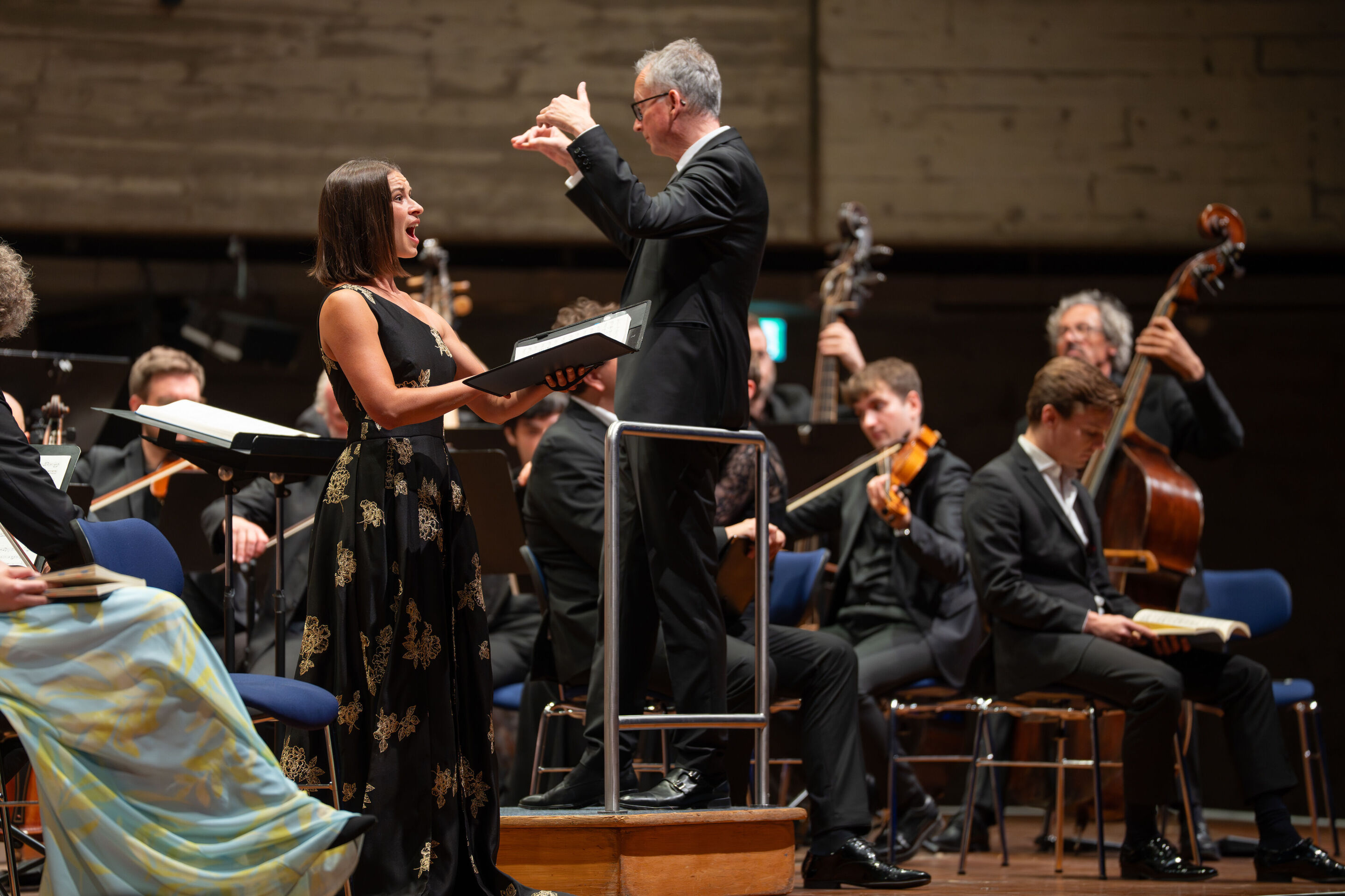 Mendelssohn’s Elijah with the Audi Young Persons’ Choral Academy - On the stage of the Festsaal Ingolstadt, soprano Marie-Sophie Pollak sings standing with a music book in her hands. To her right, Martin Steidler conducts the musicians of the Akademie...