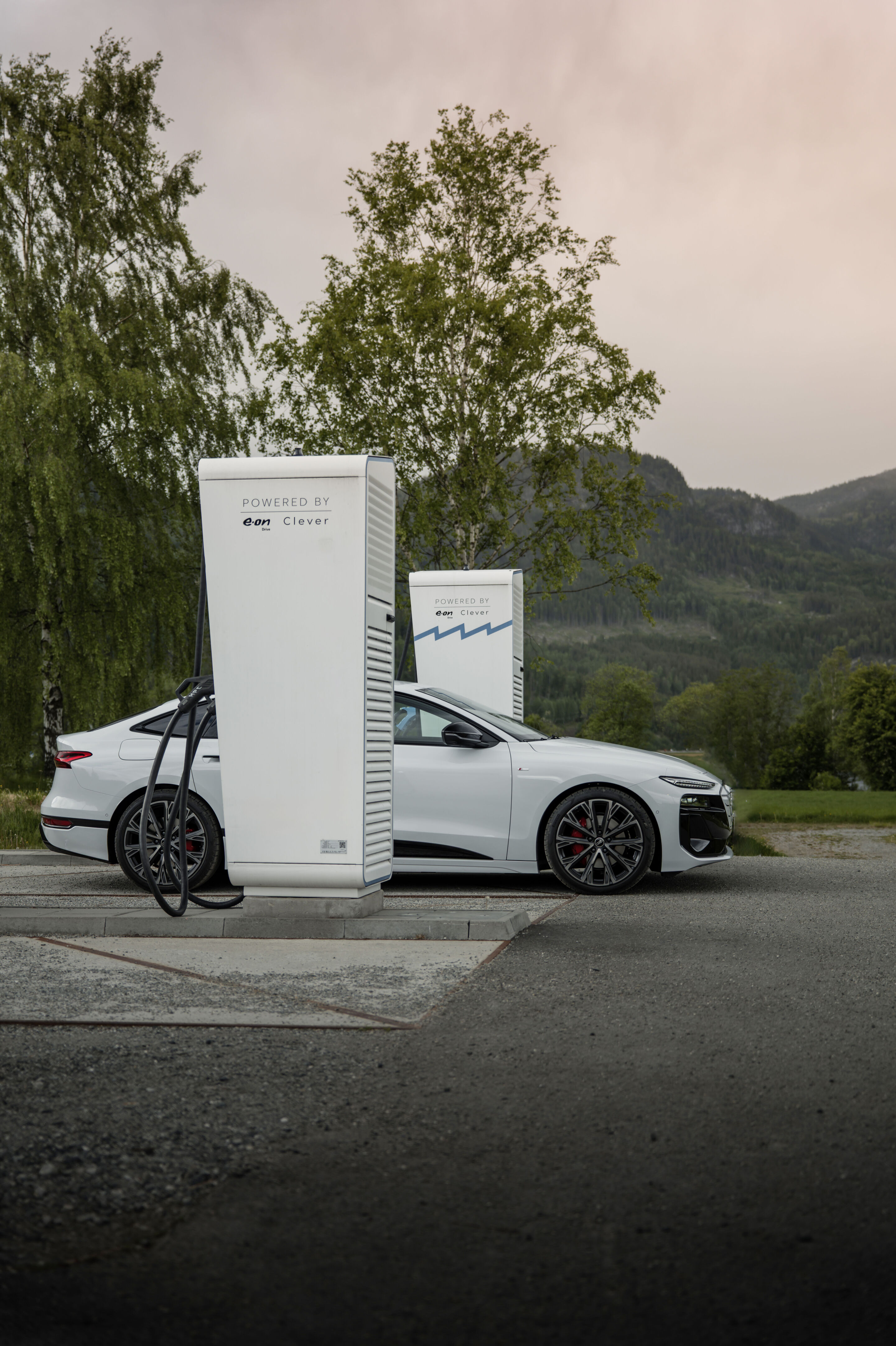 Strom aufwärts: Im Audi A6 e-tron von Kopenhagen nach Bergen - Ein Audi A6 Sportback e-tron in Gletscherweiß Metallic lädt zwischen zwei Ladesäulen.