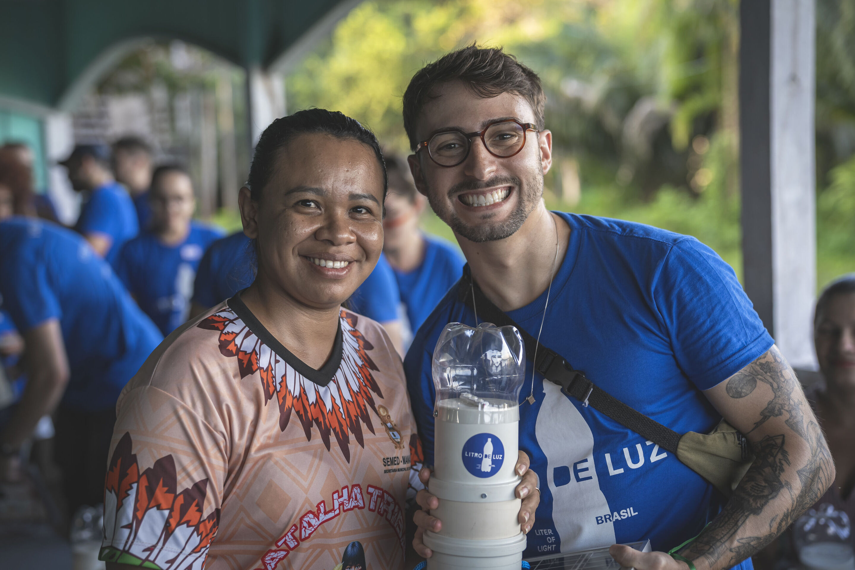 Solar lamps for Amazon communities without electricity: Audi and Litro de Luz continue partnership - A Litro de Luz employee and a Brazilian resident show a solar-powered street lamp that was made using a PET bottle, among other materials.