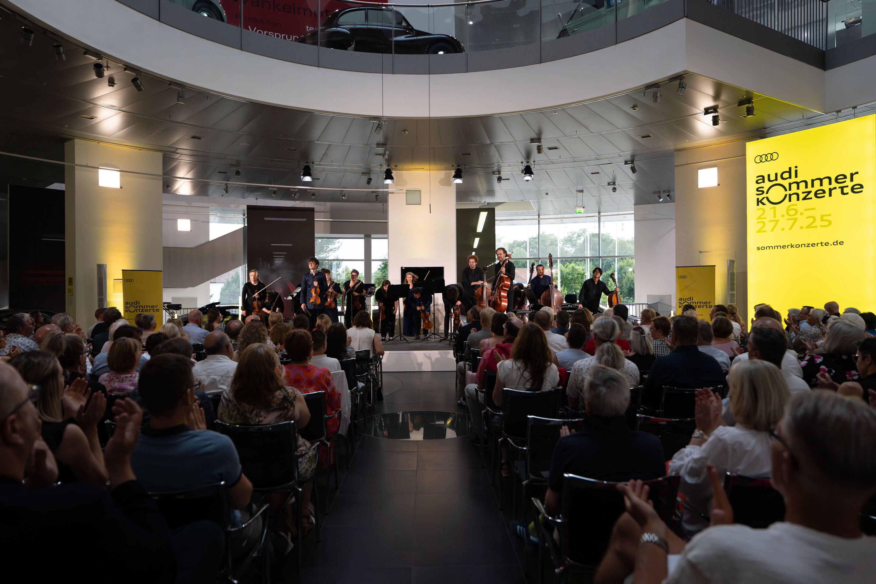 „Crossing over the Atlantic“: von Britten bis Nirvana mit dem O/Modernt Kammerorchester - Auf der Bühne des Audi museum mobile steht aus der Sicht des Publikums das O Modernt Kammerorchester unter der Leitung von Hugo Ticciati.