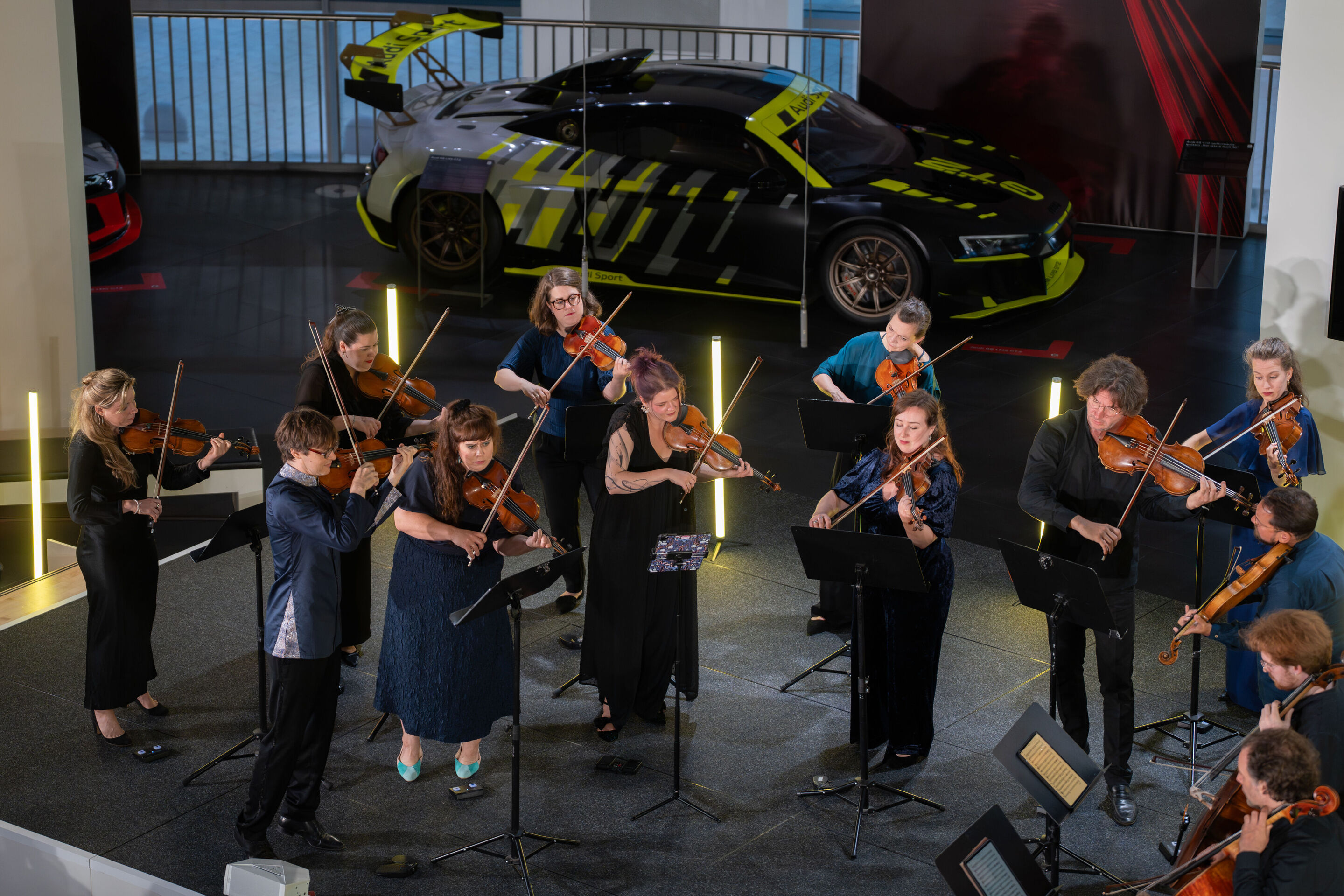„Crossing over the Atlantic“: von Britten bis Nirvana mit dem O/Modernt Kammerorchester - Aus der Vogelperspektive zu sehen ist ein Teil des O Modernt Kammerorchesters unter der Leitung Hugo Ticcianis auf der Bühne des Audi museum mobile.