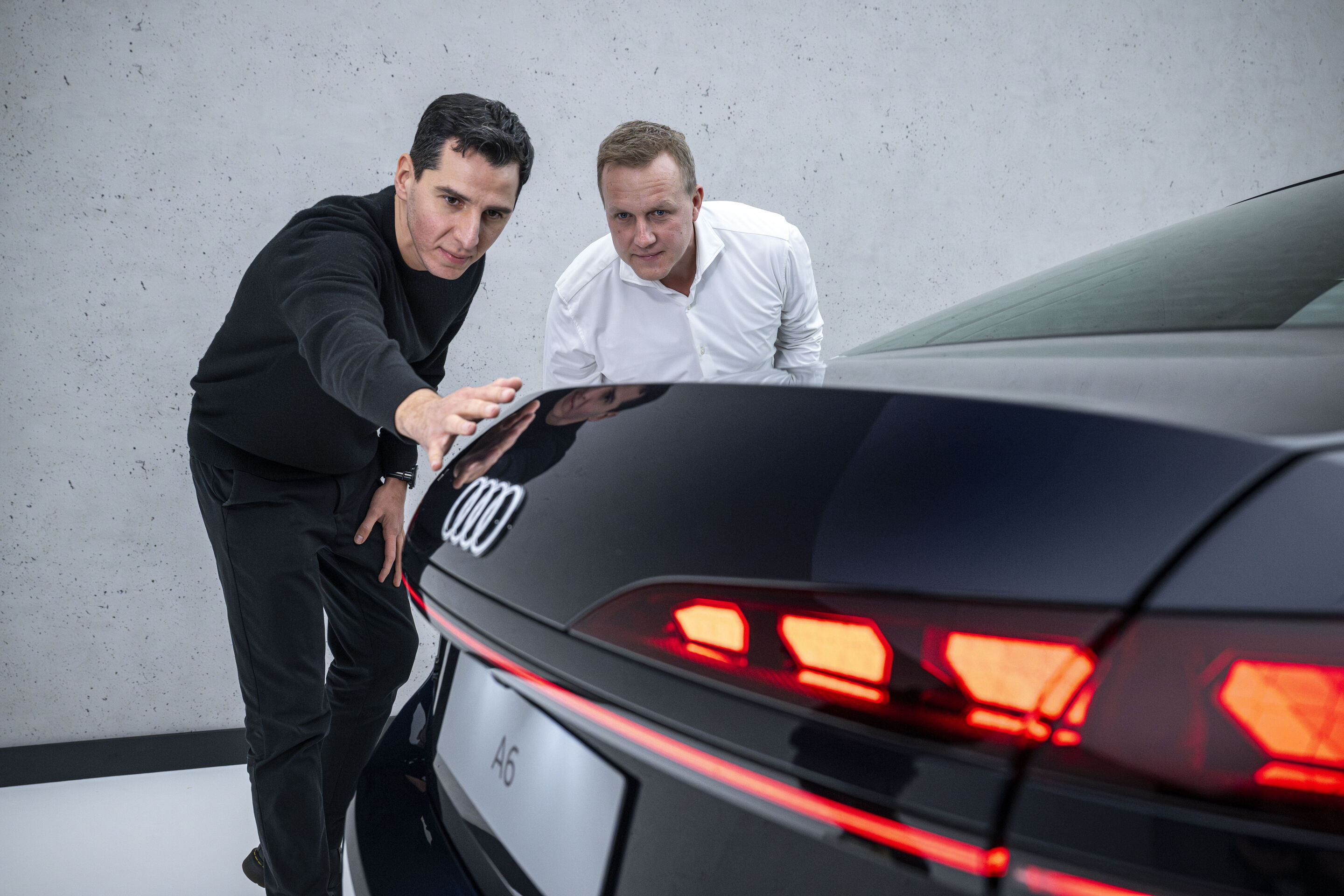 Neu im Handel verfügbar: die A6 Limousine - Exterieur-Designer Francesco d’Amore (li.) zeigt Aerodynamik-Entwickler Sebastian Weiper (re.) an der Audi A6 Limousine eine in die Heckklappe integrierte Kante, die für einen optimalen Strömungsabriss sorgt.