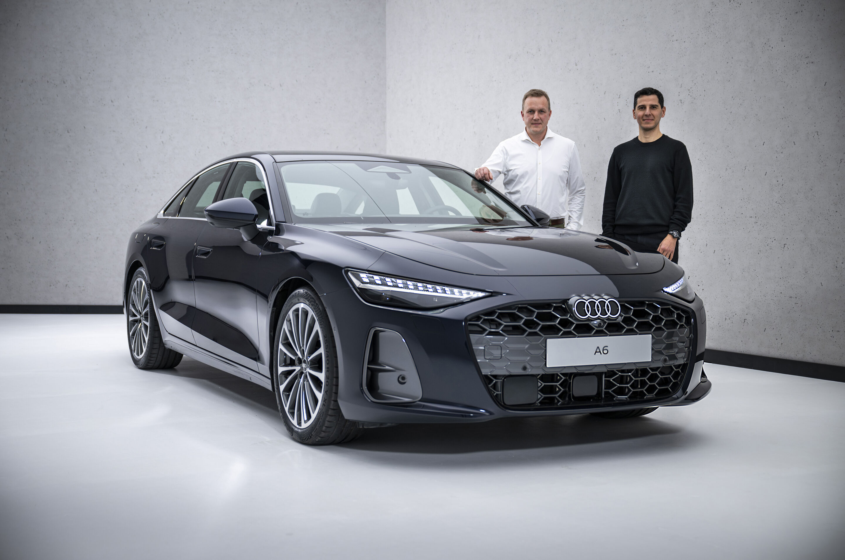Neu im Handel verfügbar: die A6 Limousine - Aerodynamik-Entwickler Sebastian Weiper (li.) und Exterieur-Designer Francesco d’Amore (re.) stehen neben der Audi A6 Limousine.