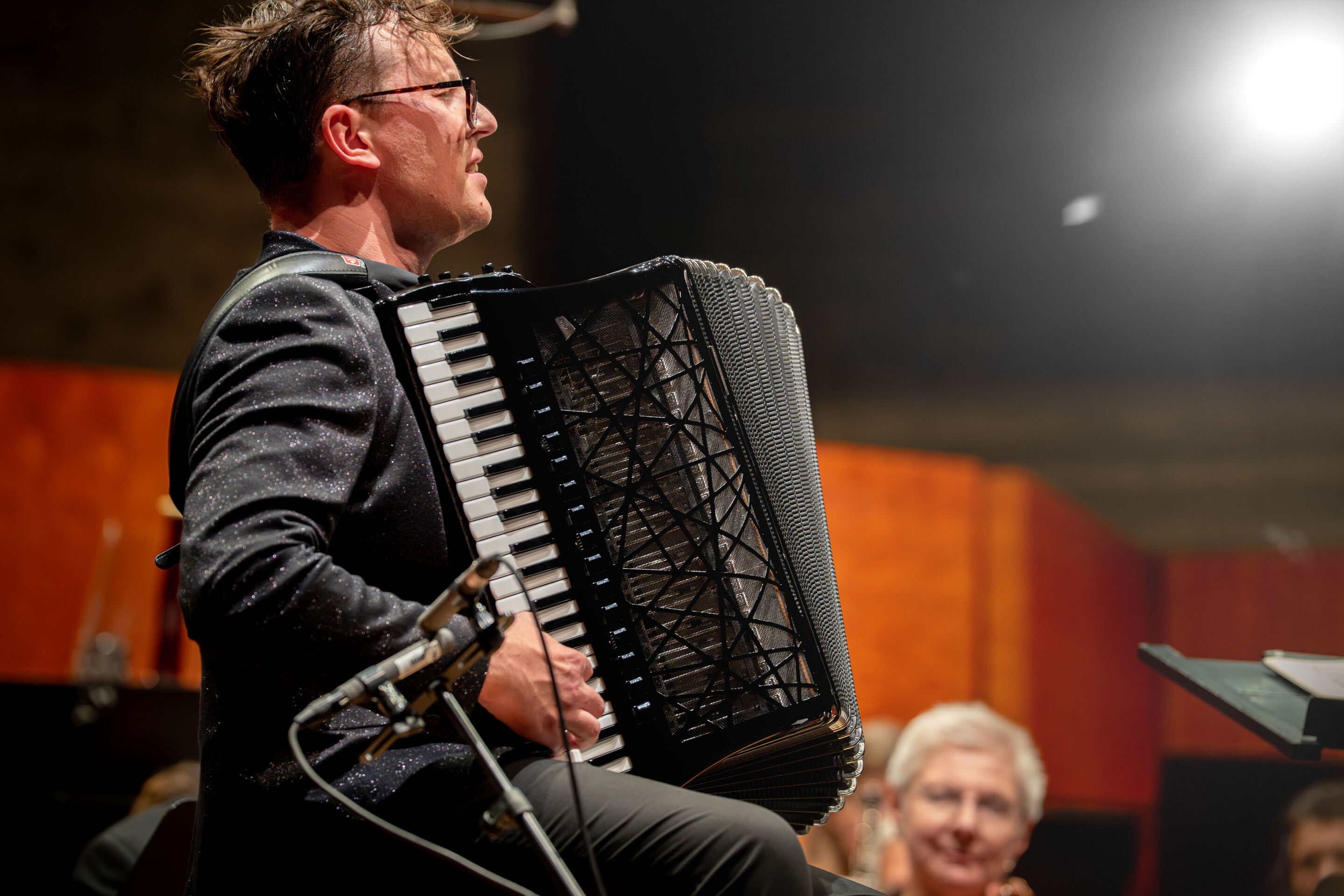 Abschlusskonzert mit Akkordeonstar Martynas Levickis und der Deutschen Kammerphilharmonie Bremen - Nahaufnahme des Akkordeonstars Martynas Levickis inmitten der Deutschen Kammerphilharmonie Bremen auf der Bühne des Festsaals Ingolstadt.