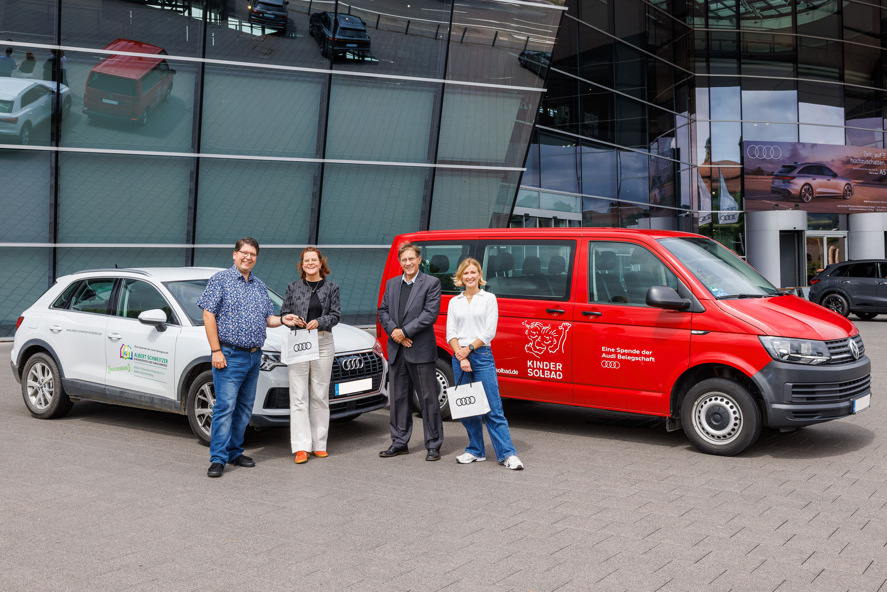 Audi Belegschaft spendet Fahrzeuge für Kinder- und Jugendhilfeeinrichtungen in der Region - Alexander Reinhart übergibt kleine Glücksbringer mit den gespendeten Fahrzeugen an Susanne Wirth und Wolfgang Bartole vom Albert-Schweitzer Kinderdorf und Angelina...