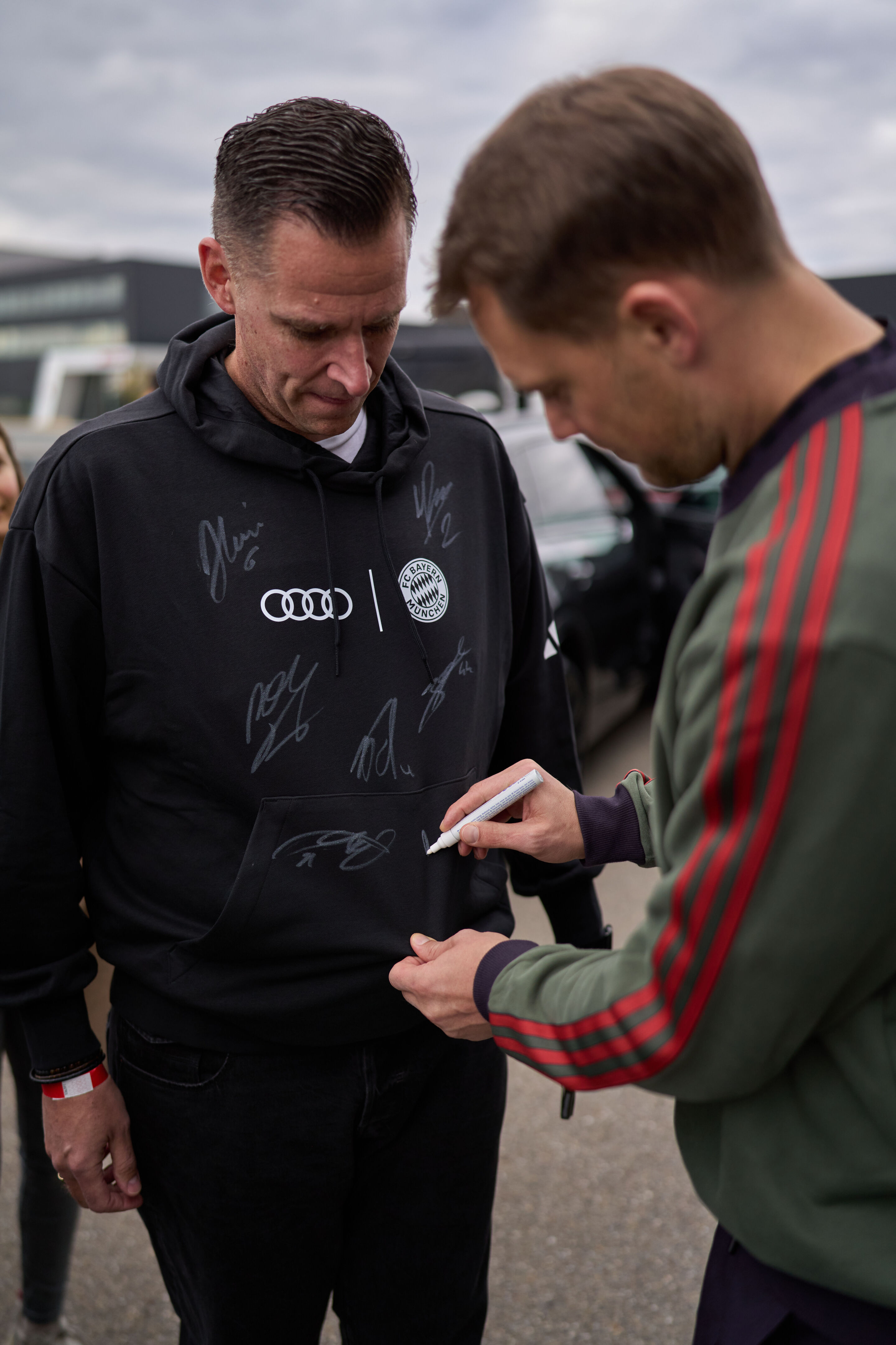 Audi übergibt neue Dienstwagen an FC Bayern München - Im Rahmen der Fahrzeugübergabe nahmen sich die Bayern-Stars wie Manuel Neuer Zeit für Autogramme für die Audi Mitarbeitenden.