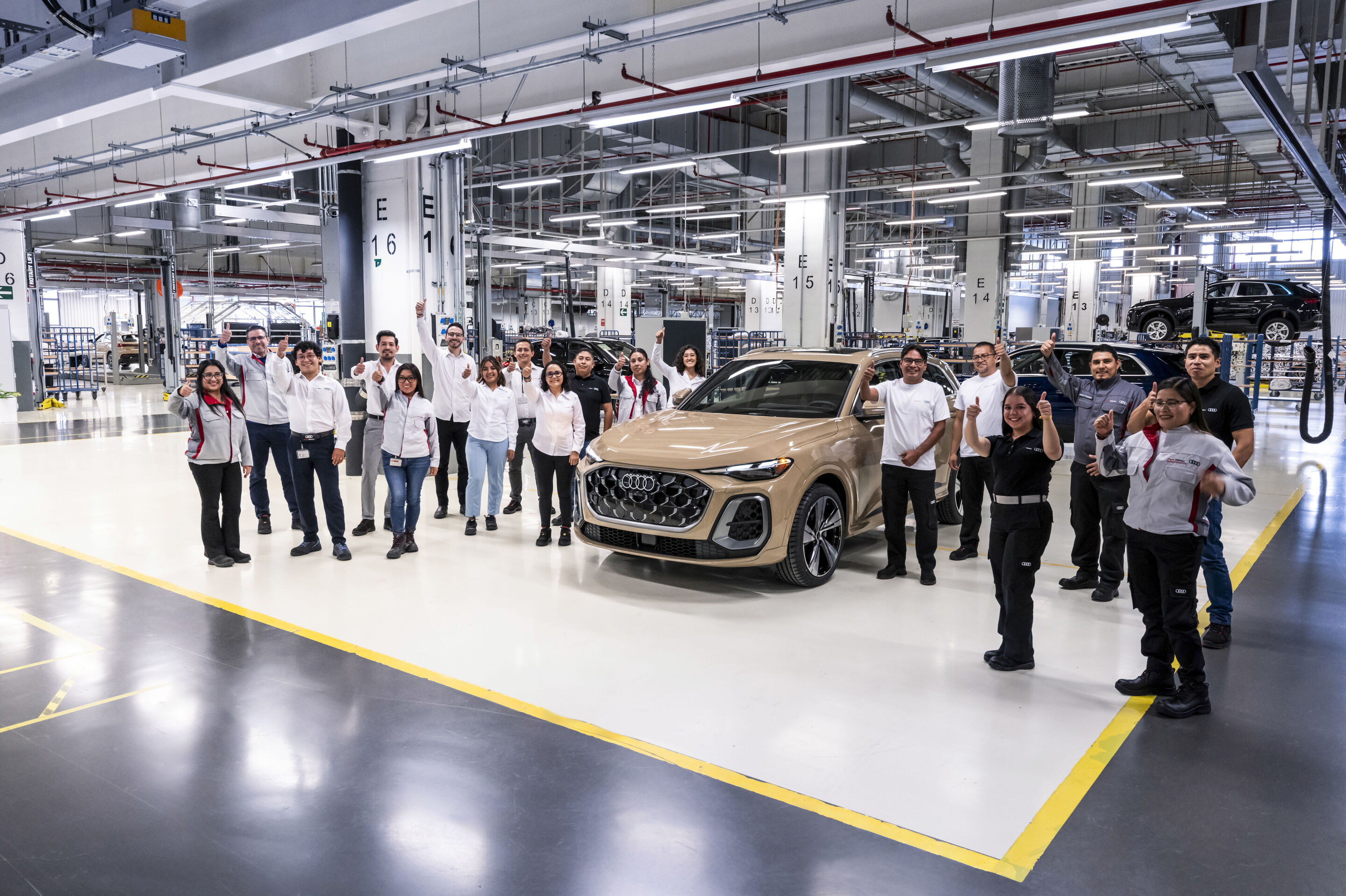 Audi Q5 production at San José Chiapa site - Teamwork: Employees present a new Audi Q5 on the production line
