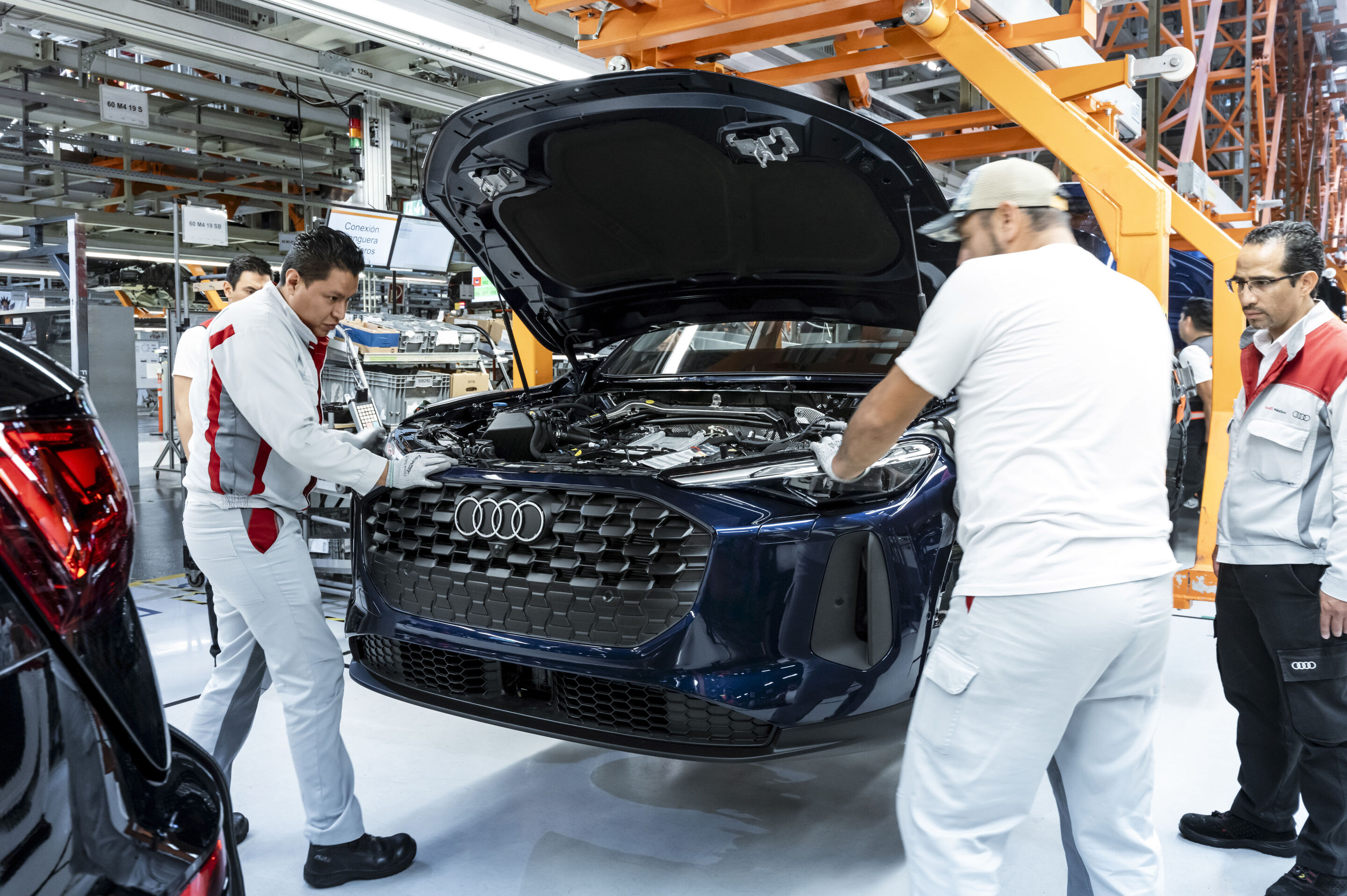 Audi Q5 production at San José Chiapa site - The headlights of a new Audi Q5 are carefully fitted by production staff