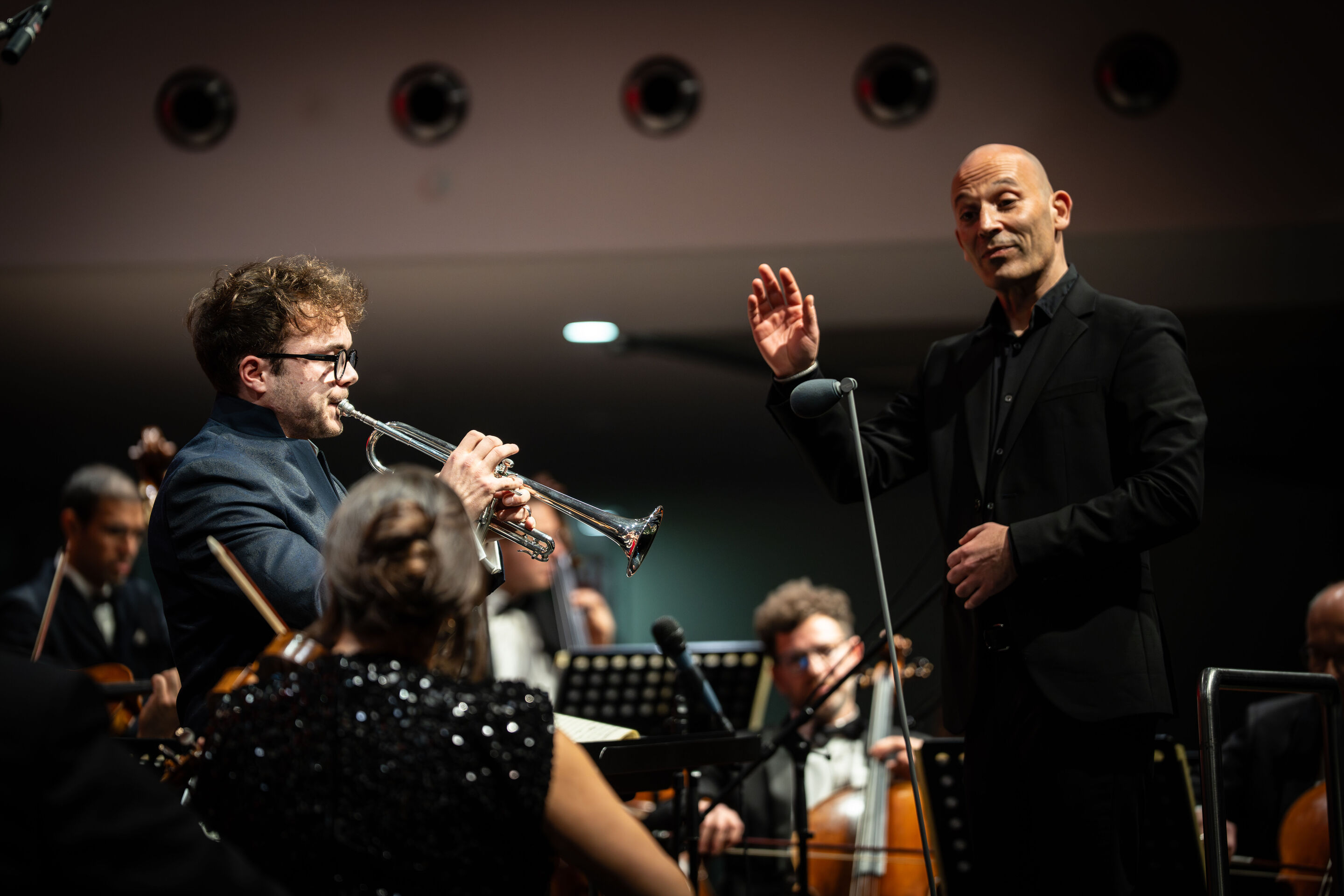 Audi Weihnachtskonzert 2025 - Trompeter Robin Paillet und Dirigent Ariel Zuckermann (v. l.), auf der Bühne beim Audi Weihnachtskonzert 2025