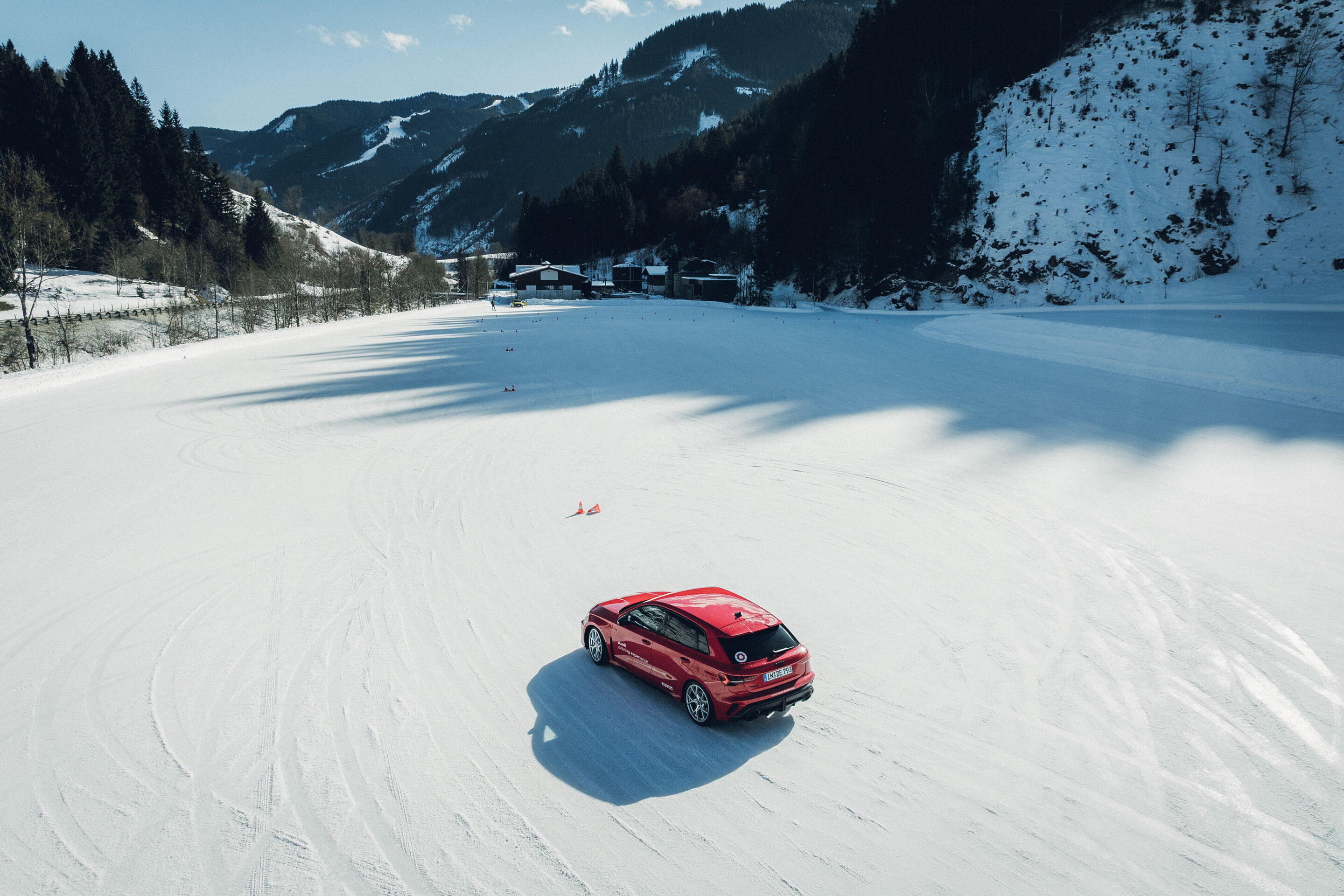 Audi RS 3 Sportback - Ein Audi RS 3 Sportback in Progressivrot fährt auf einer verschneiten Fläche.