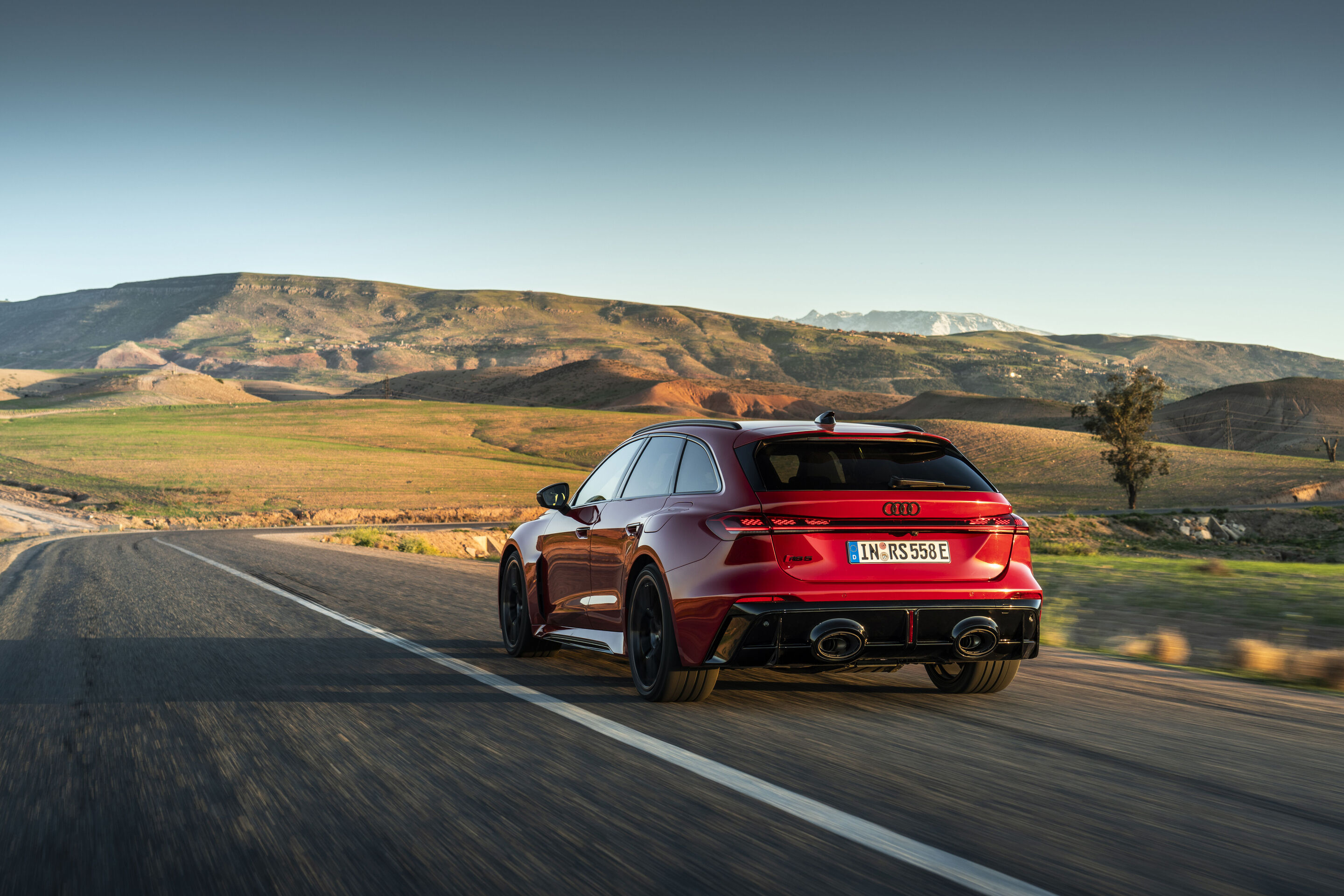 Audi RS 5 Avant - The Audi RS 5 Avant in Progressiv red on an open country road in the Atlas Mountains – confident acceleration and high stability on long straights.