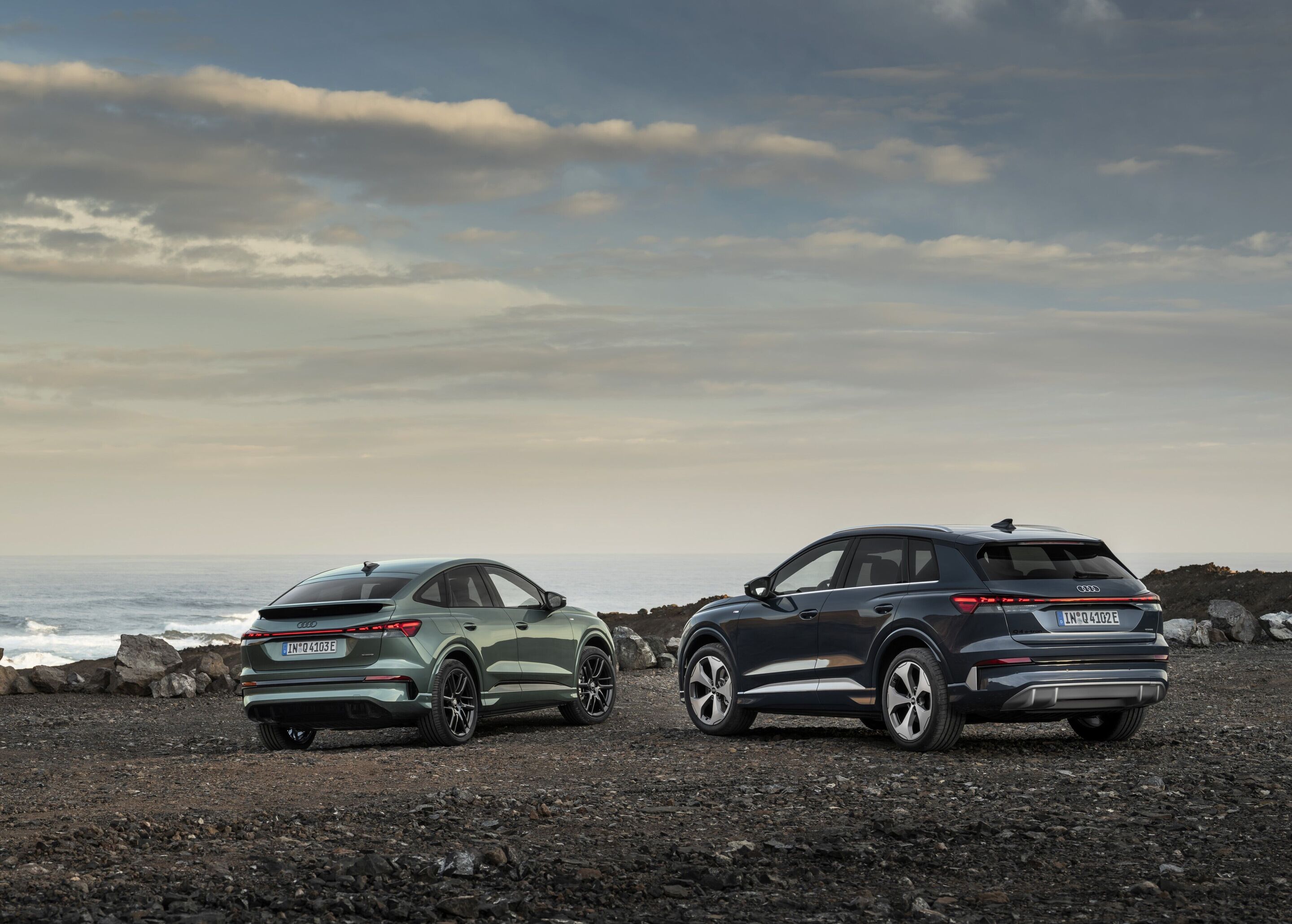 Audi Q4 Sportback e-tron / Audi Q4 SUV e-tron - Von links im Bild: Q4 Sportback e-tron in Salbeigrün Metallic, Q4 e-tron in Plasmablau, Outdoor-Standaufnahme