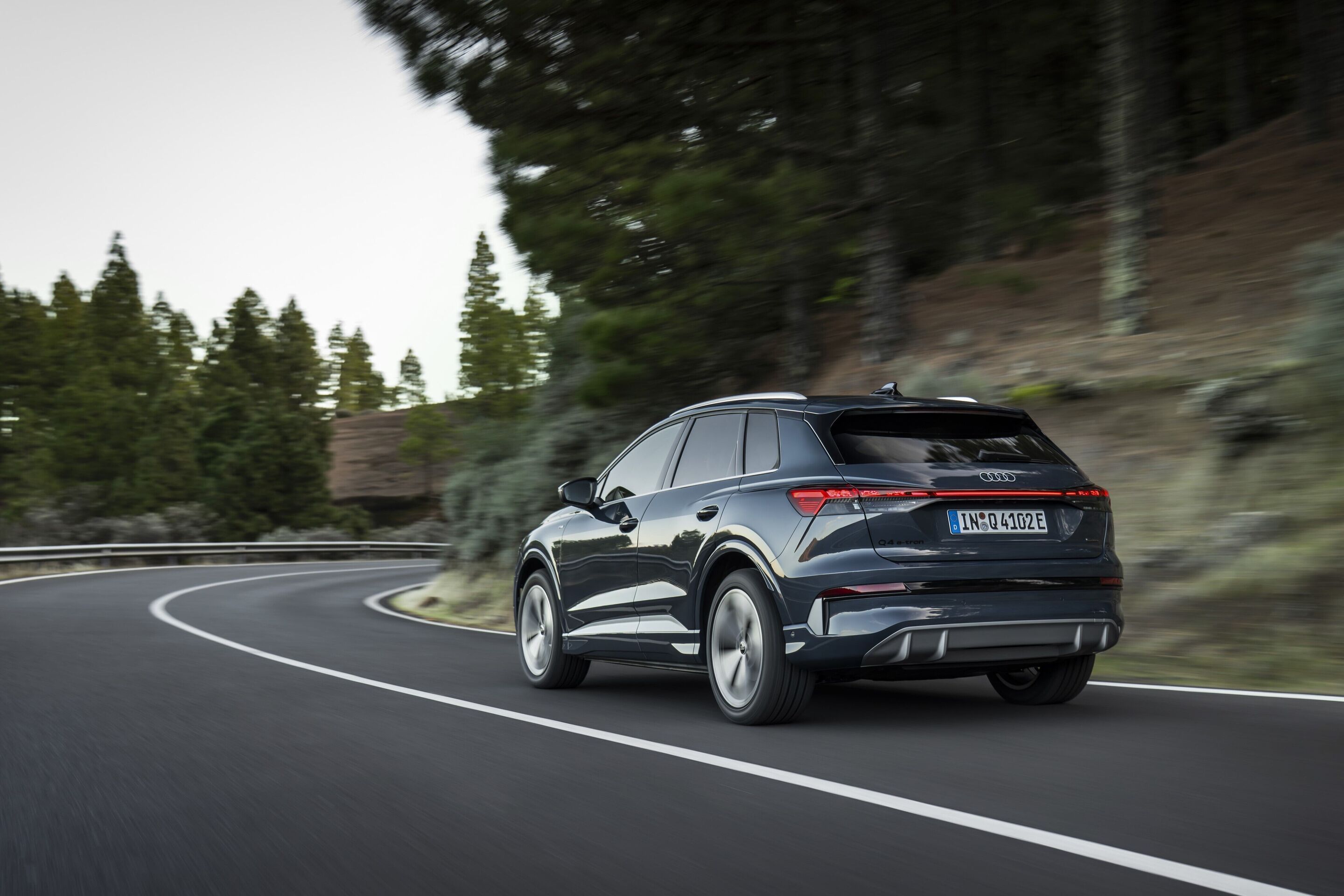 Audi Q4 SUV e-tron - Plasma blue, outdoor dynamic photo, exterior, three-quarter rear view