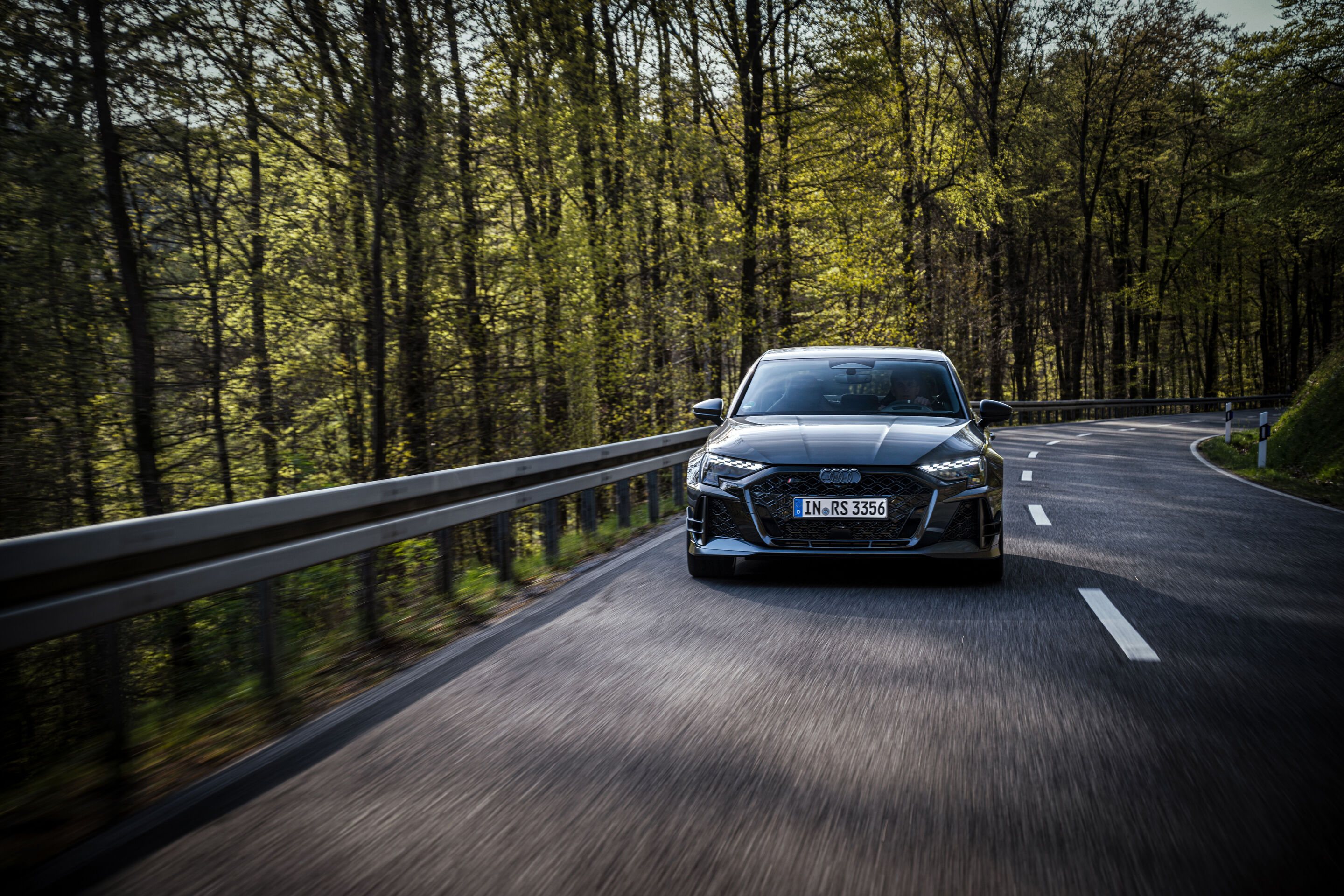 50 Jahre Fünfzylinder - Ein Audi RS3 competition limited fährt auf einer kurvigen Waldstraße.