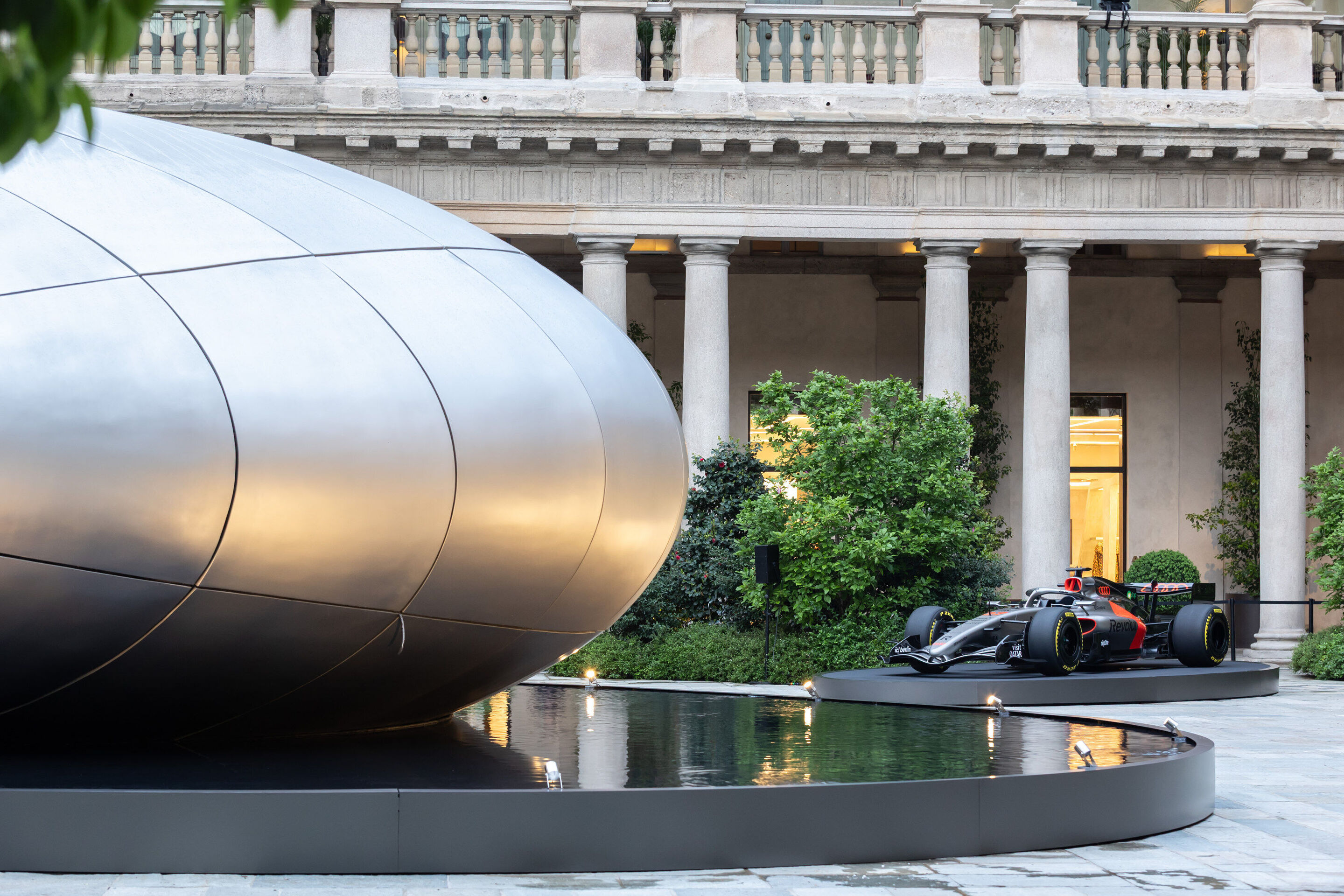 Audi auf der Milan Design Week 2026 - Seitliche Gesamtansicht der Installation „Origin“. Im Hintergrund ist das Audi Formel 1 Showcar Audi R26 zu sehen.