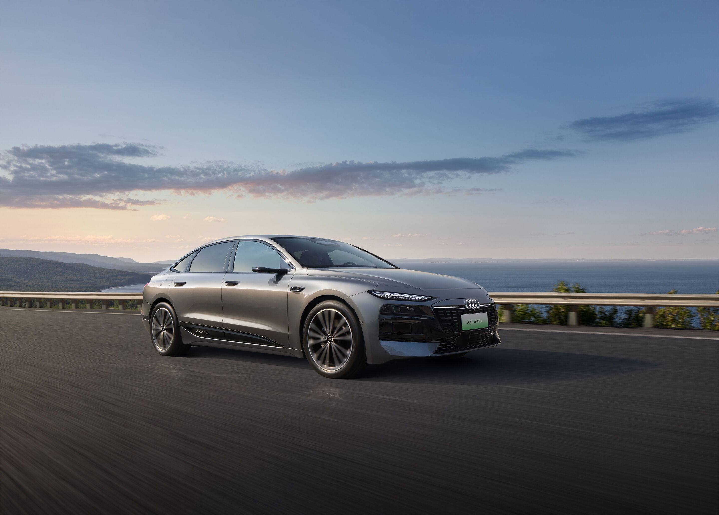 Audi auf der Auto China 2026 - Audi A6L e-tron, Outdoor-Fahraufnahme, Exterieur, Dreiviertelfrontansicht auf Küstenstraße