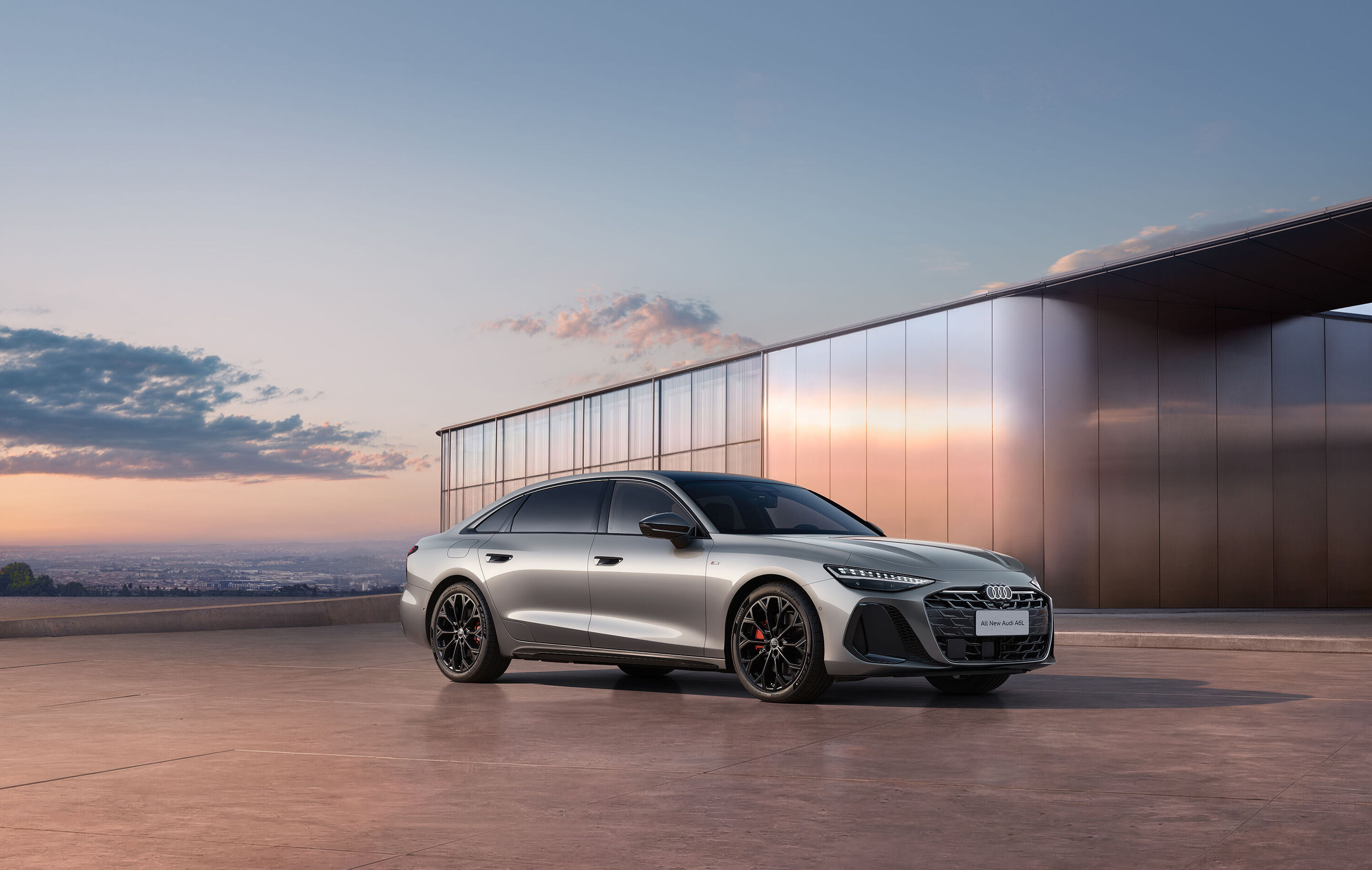 Audi at Auto China 2026 - Audi A6L, outdoor static shot, exterior, three-quarter front view in front of modern architecture in evening light