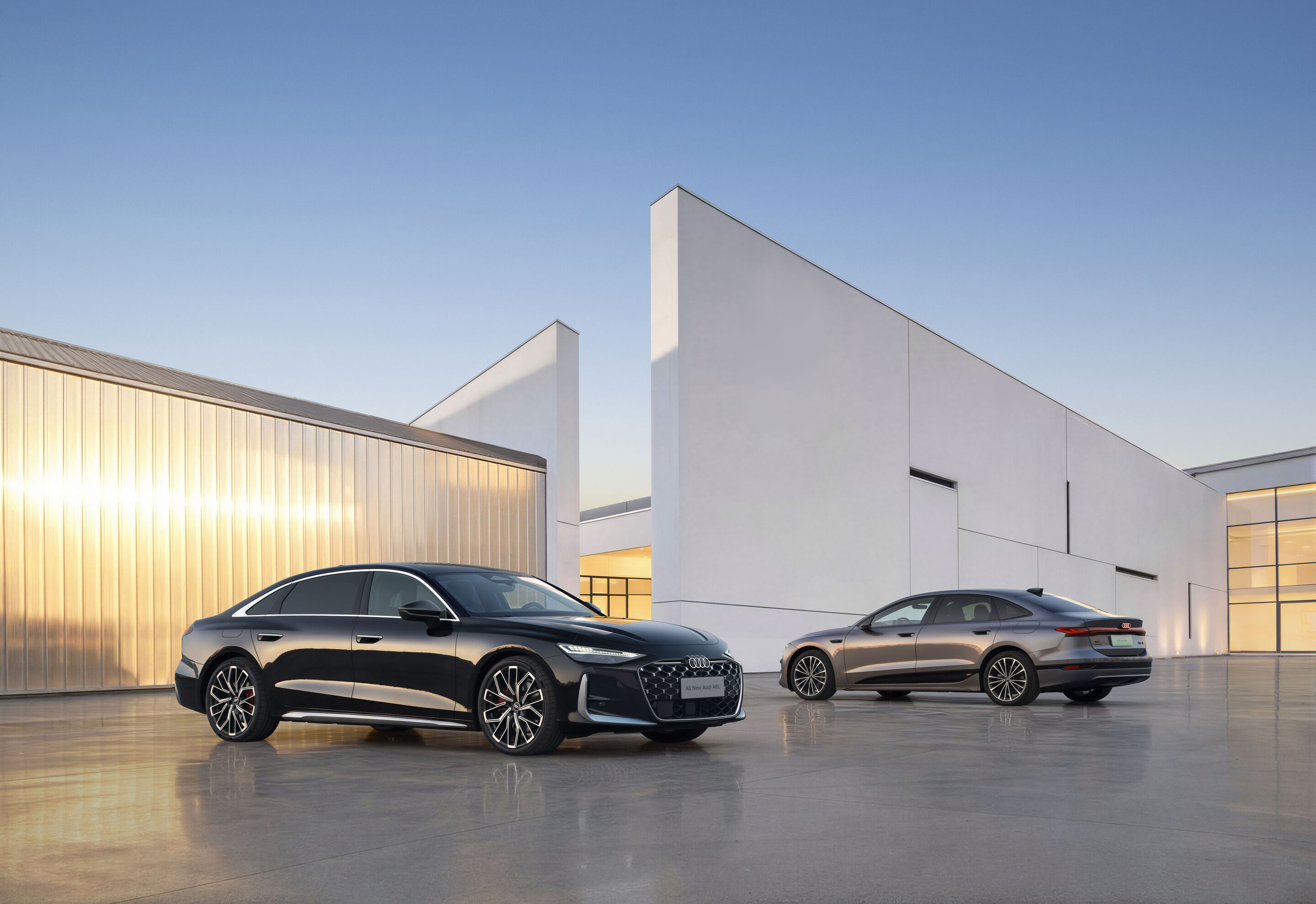 Audi auf der Auto China 2026 - Von links im Bild: Audi A6L, Audi A6L e-tron, Outdoor-Standaufnahme, Exterieur, jeweils Dreiviertelfront- und Seitenansicht, vor moderner Architektur