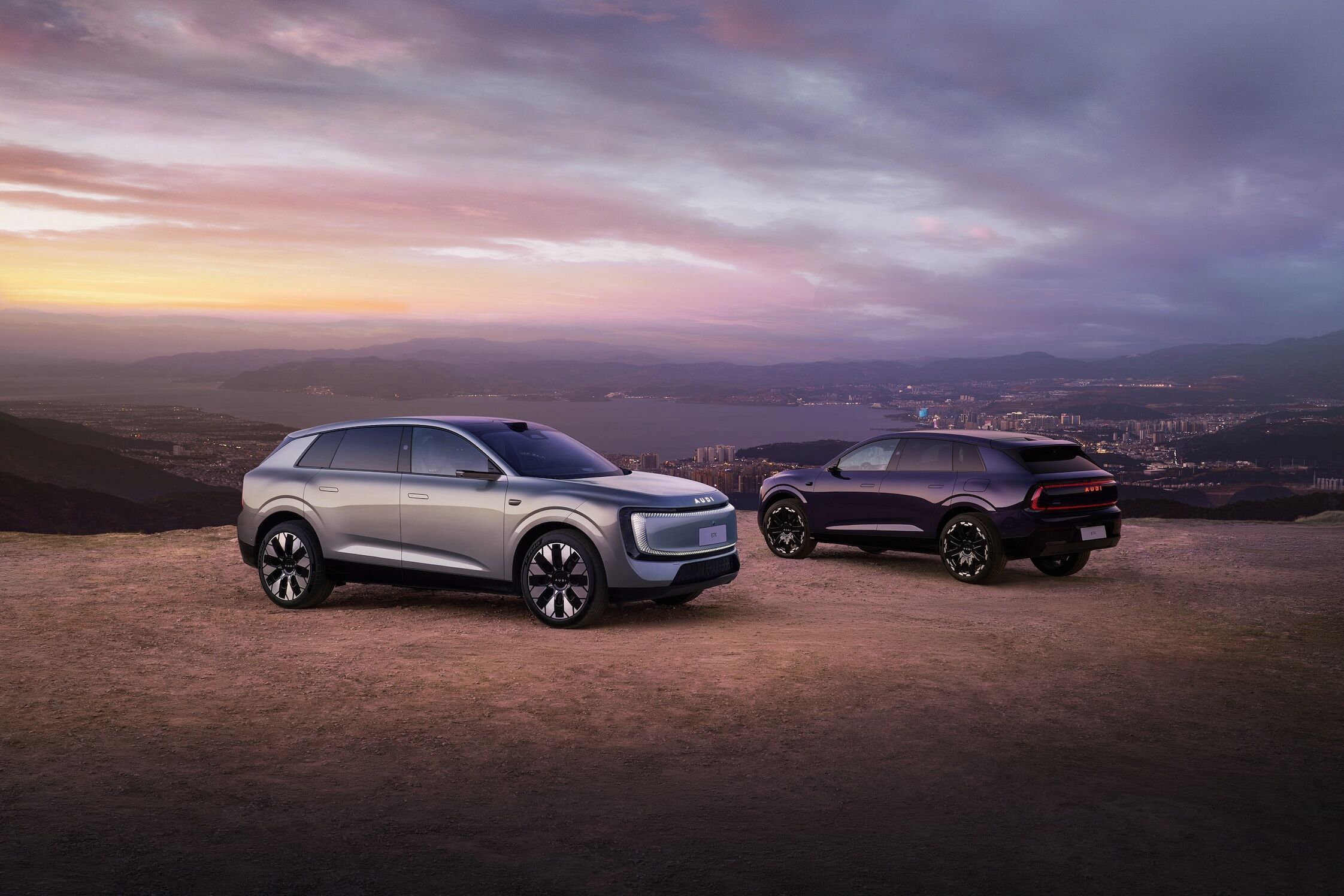 Audi auf der Auto China 2026 - Audi E7X, Outdoor-Standaufnahme, Exterieur, Dreiviertelfront- und Dreiviertelheckansicht vor urbaner Landschaft bei Abenddämmerung