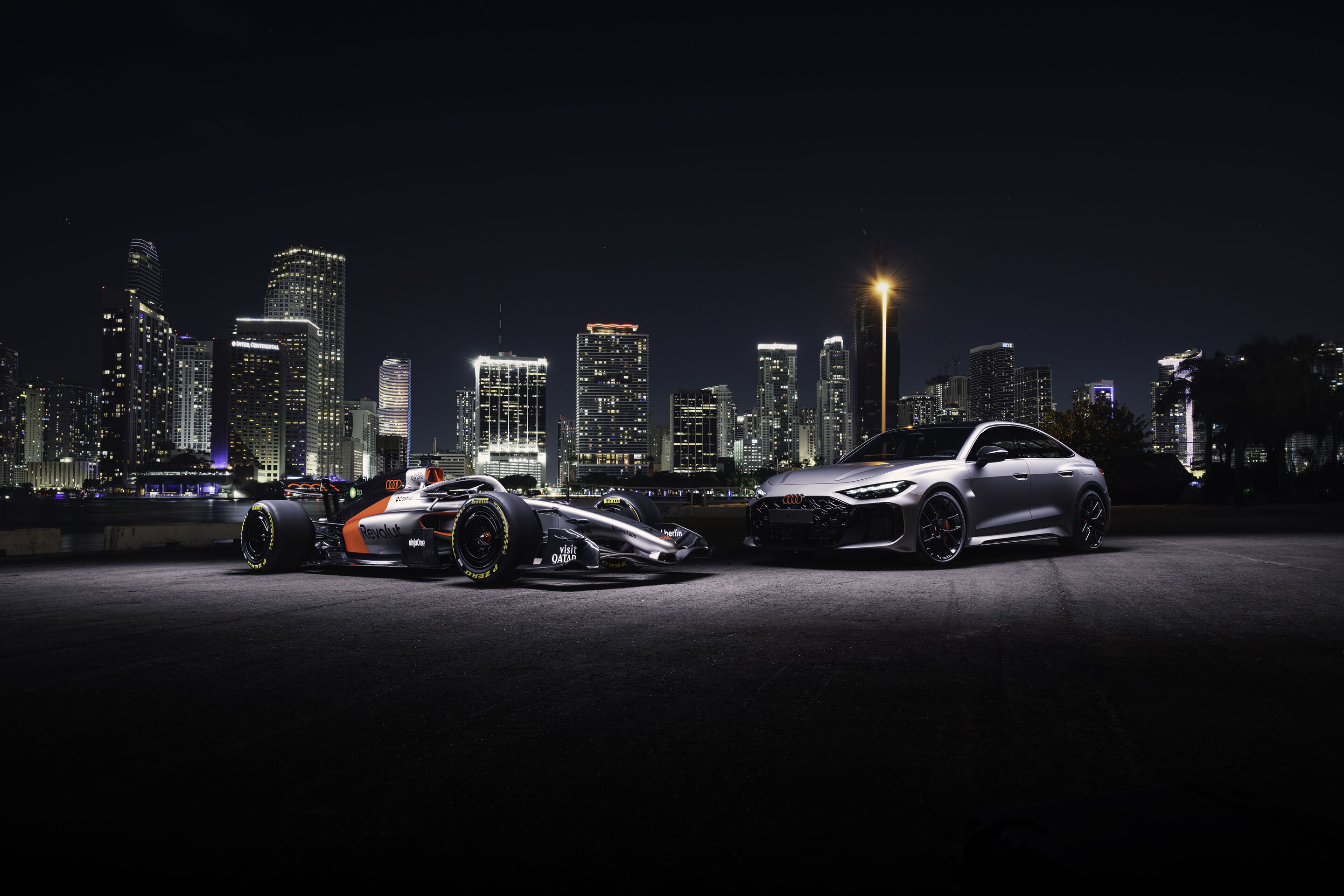 Audi RS 5: Premiere als Hot-Lap-Auto bei der Formel 1 - Der Audi RS 5 neben dem Audi R26 vor der nächtlichen Skyline von Miami. Der RS 5 feiert beim F1 Grand Prix in Miami seine Premiere als Fahrzeug für die F1® Pirelli Hot Laps im Rahmenprogramm der...