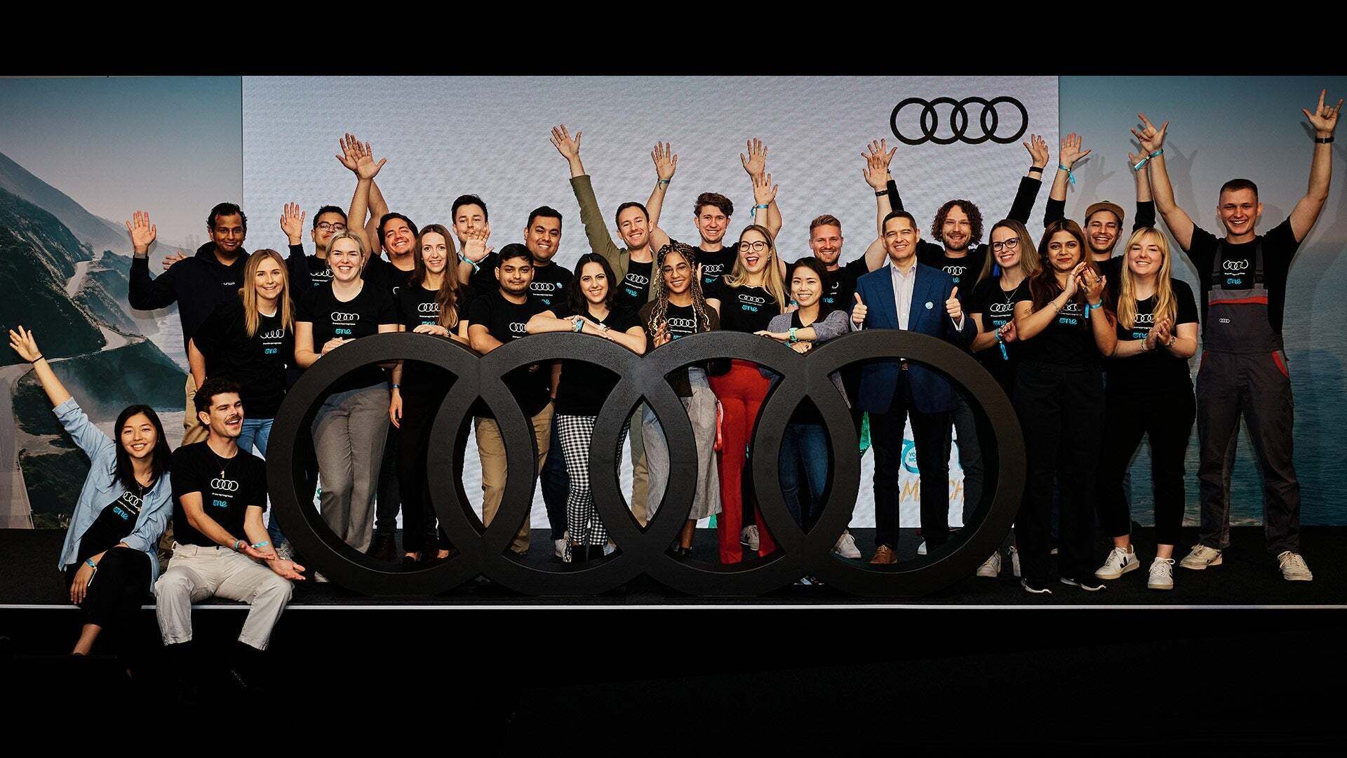 Gruppe freudig jubelnder Jugendlicher auf der Bühne eines Audi Events. - Bei unseren Veranstaltungen erhältst du weitere Informationen über Einstiegsmöglichkeiten. Wir freuen uns auf dich!