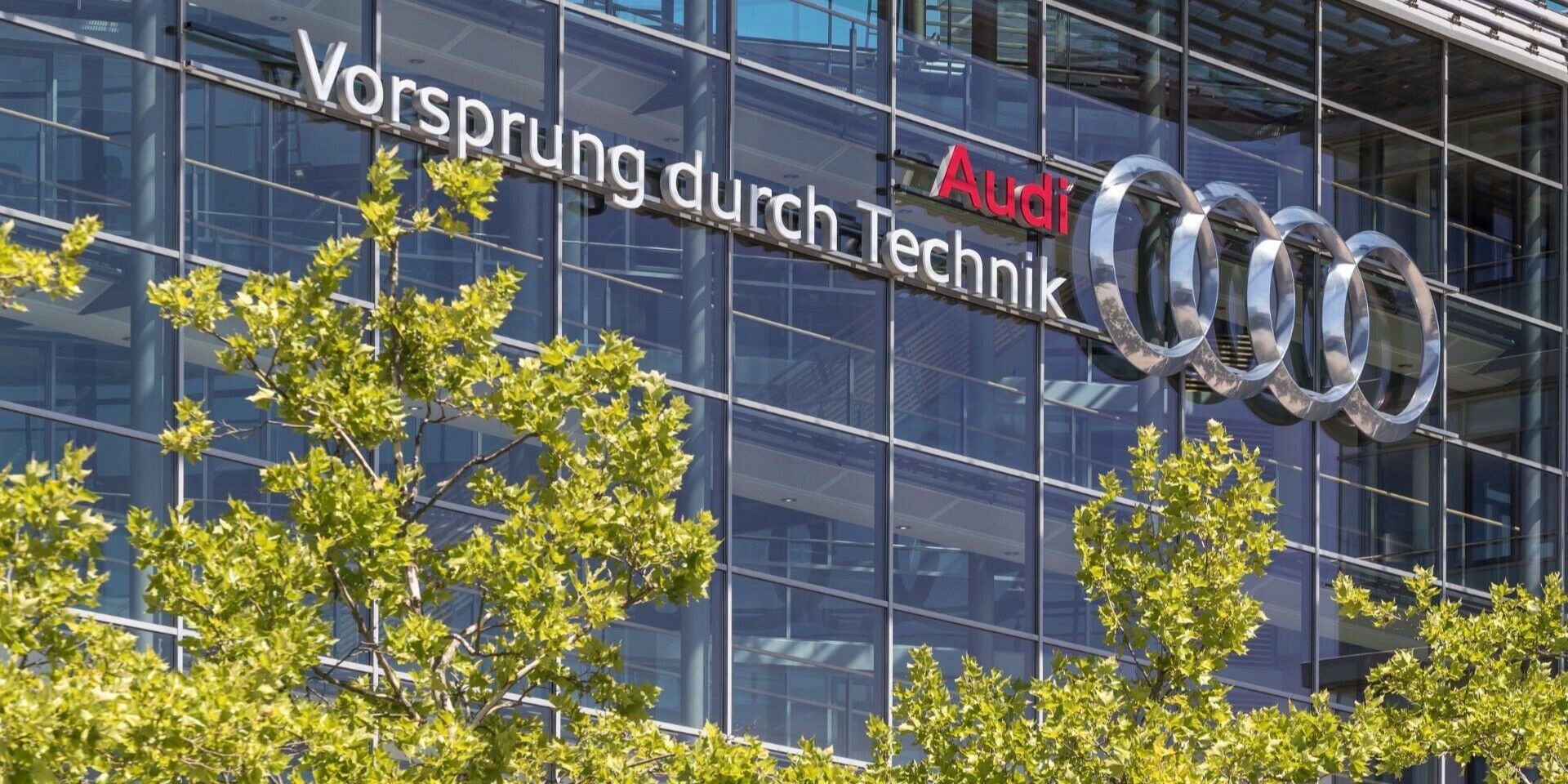 Außenansicht eines Audi-Standorts mit Logo und Claim