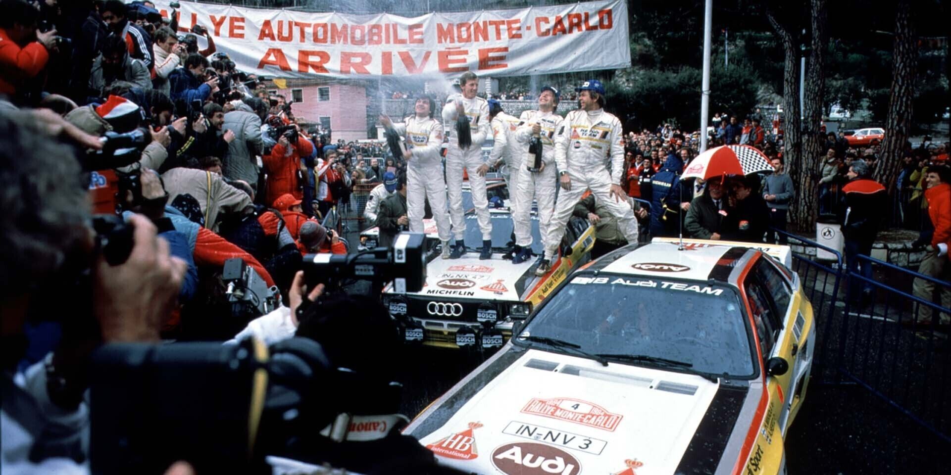 Das Foto zeigt das Audi Sport-Team, das einen Dreifacherfolg bei der Rallye Monte Carlo 1984 feiert.