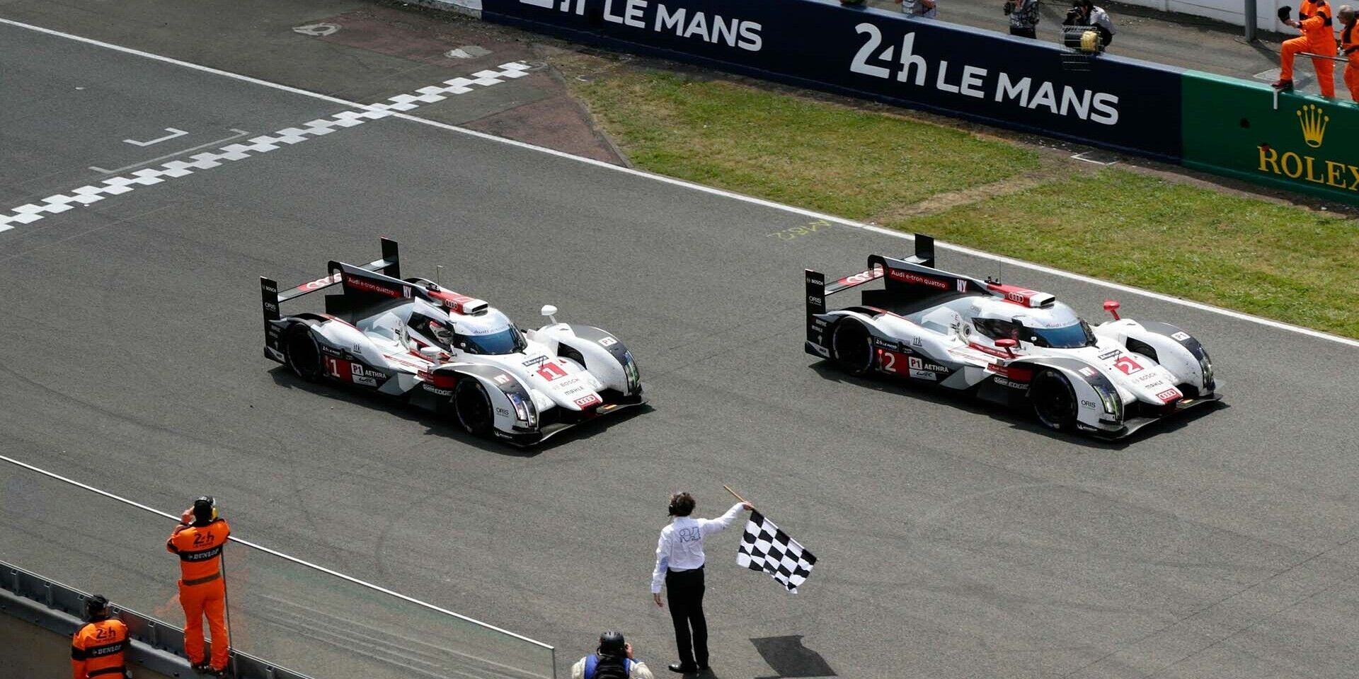 Das Foto zeigt Audi R18 e-tron quattro-Rennwagen beim Überqueren der Ziellinie der 24 Stunden von Le Mans 2014.