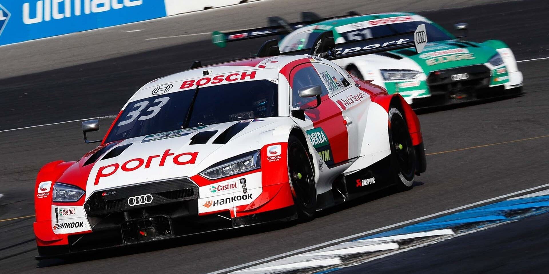 Das Foto zeigt zwei Audi RS 5 DTM-Rennwagen auf der Rennstrecke in Hockenheim.