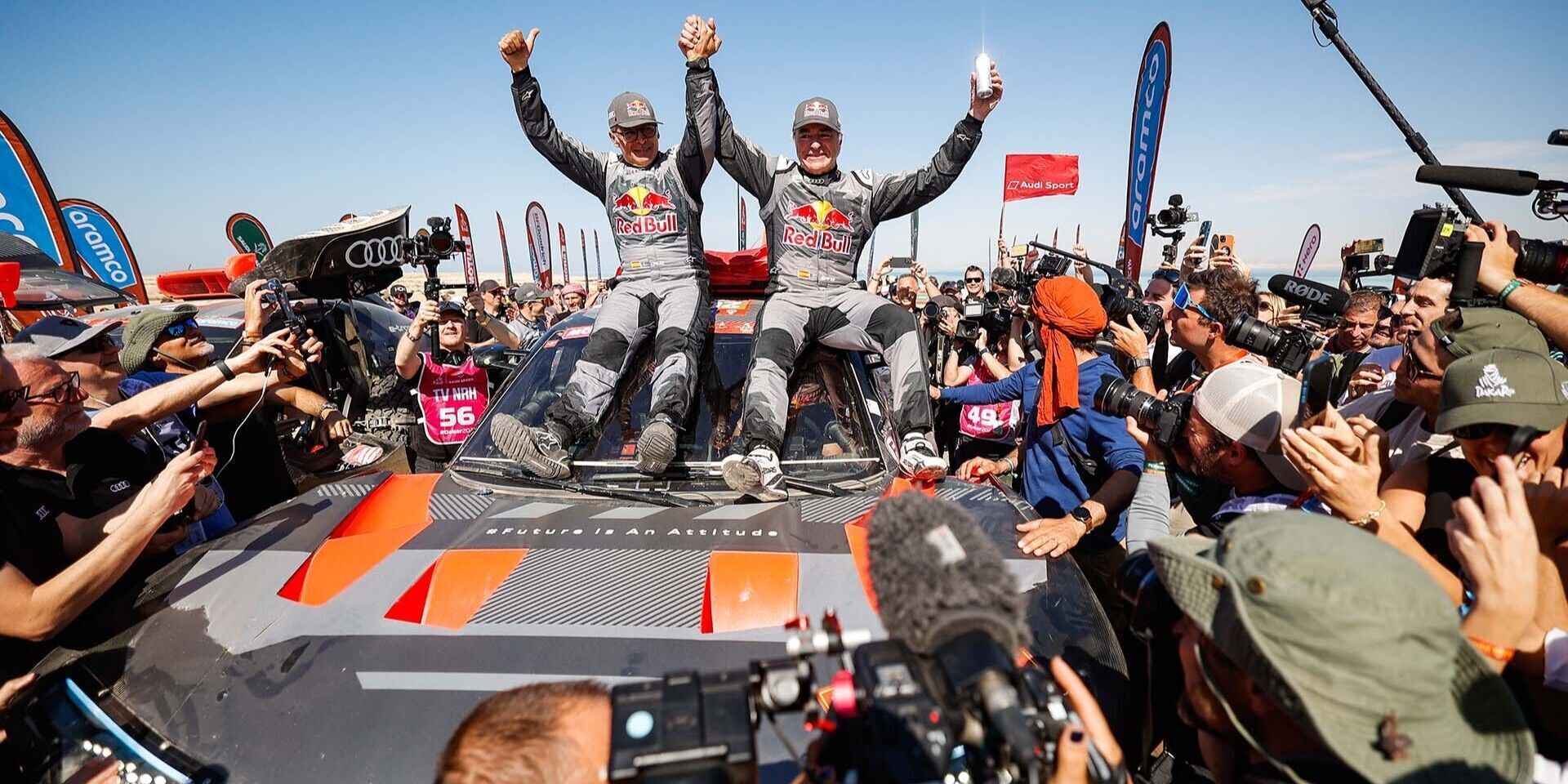 Das Foto zeigt Carlos Sainz und Lucas Cruz, die ihren Sieg bei der Rallye Dakar 2024 feiern.